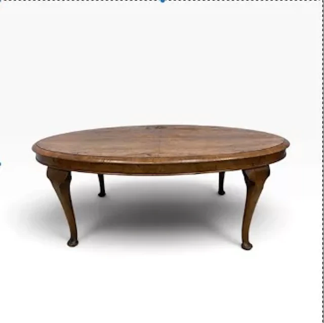 An oval figured walnut coffee table with a 19th century top on later