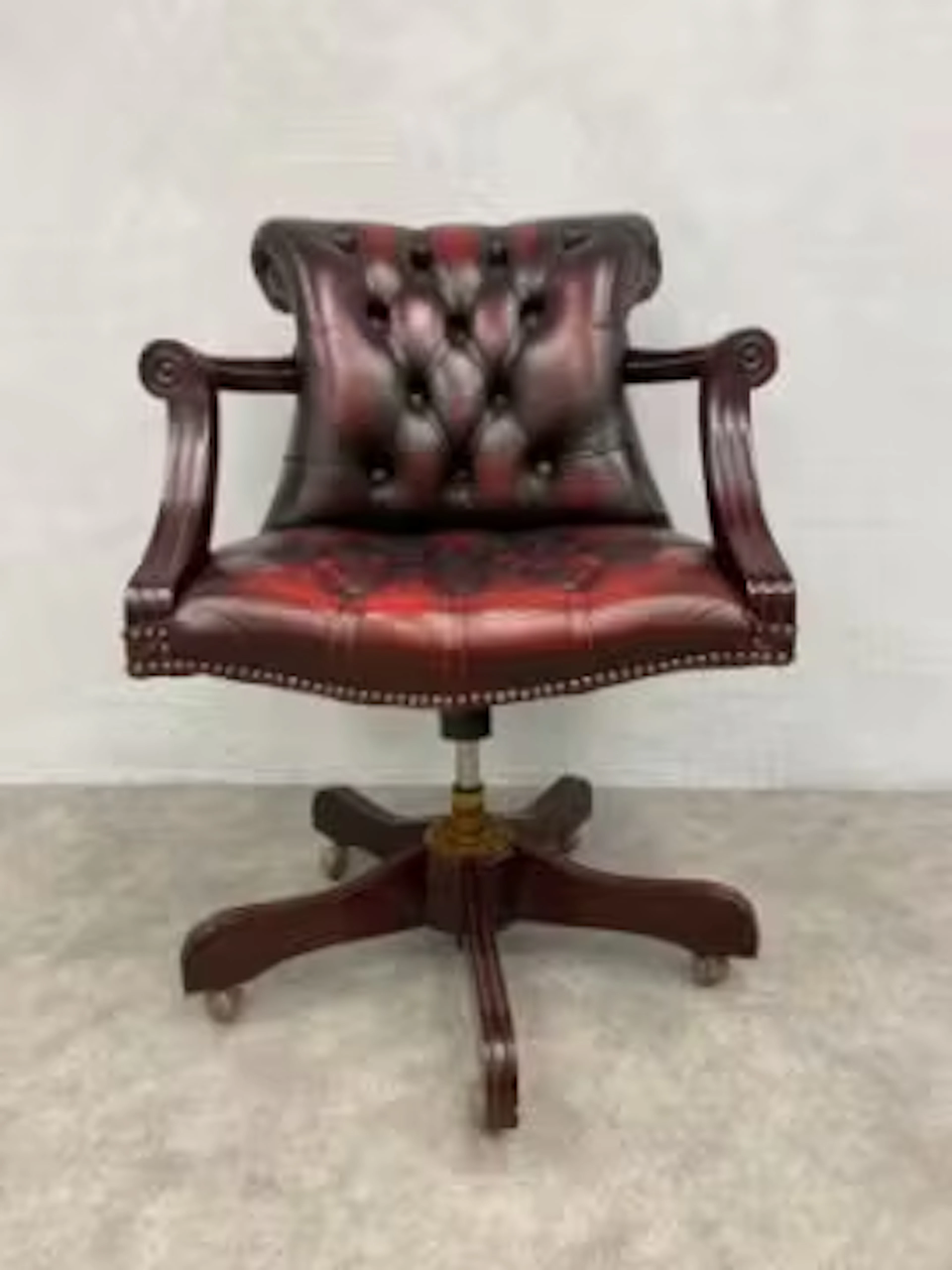A 19th century style swivel action captain's desk chair in deep buttoned