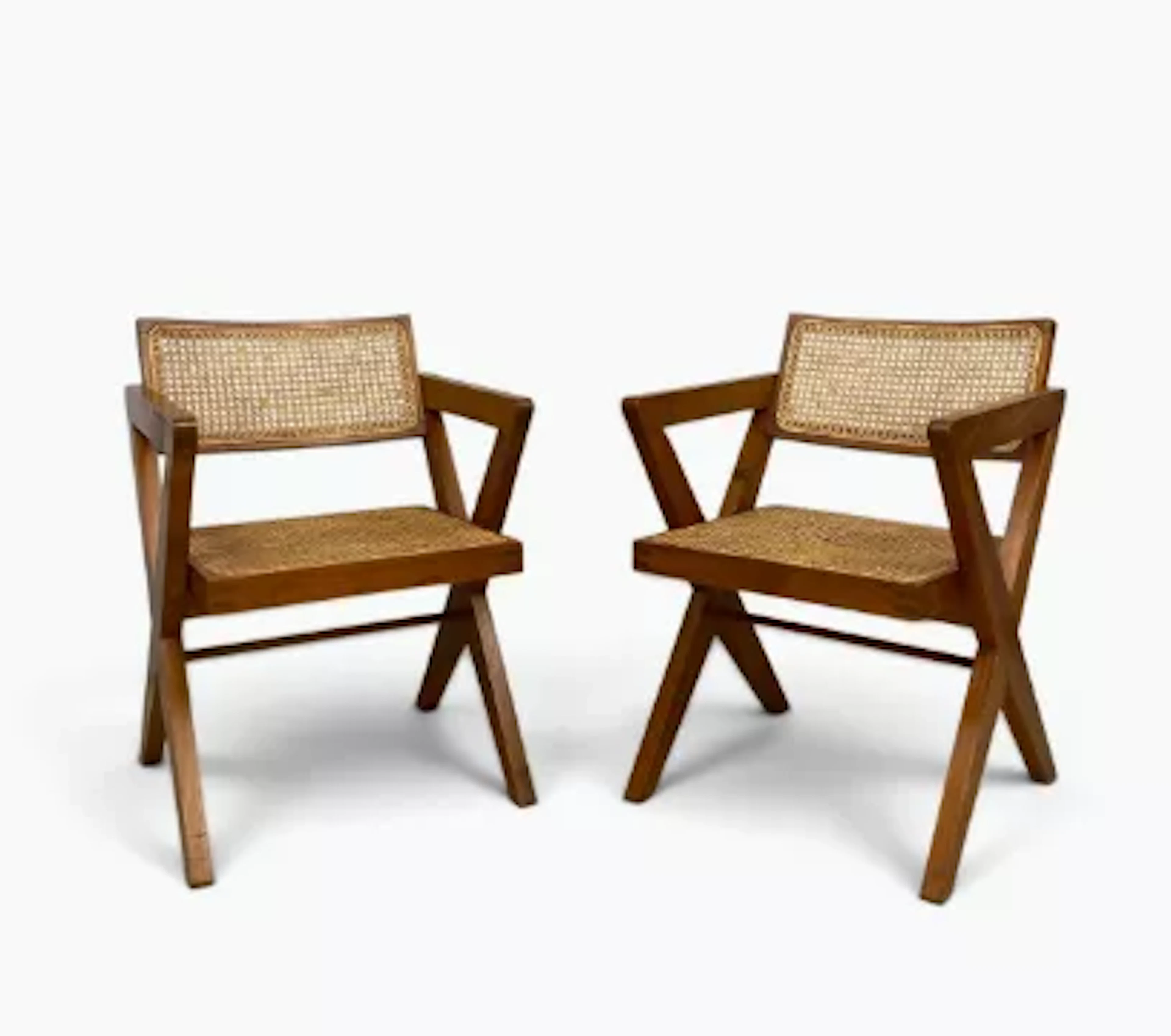 In the manner of Pierre Jeanneret, a pair of teak and rattan armchairs