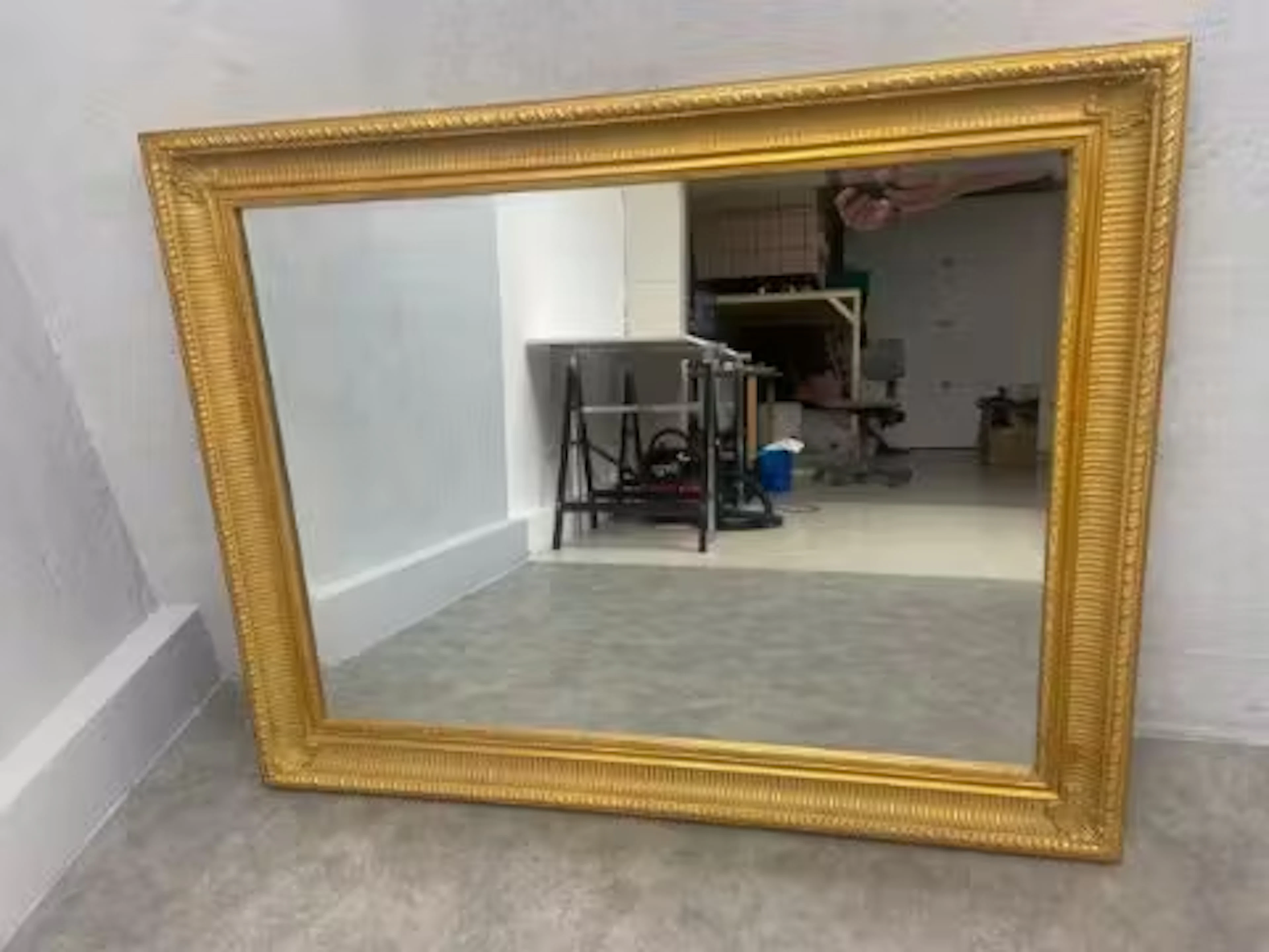 A large contemporary giltwood and gesso wall mirror with bevelled