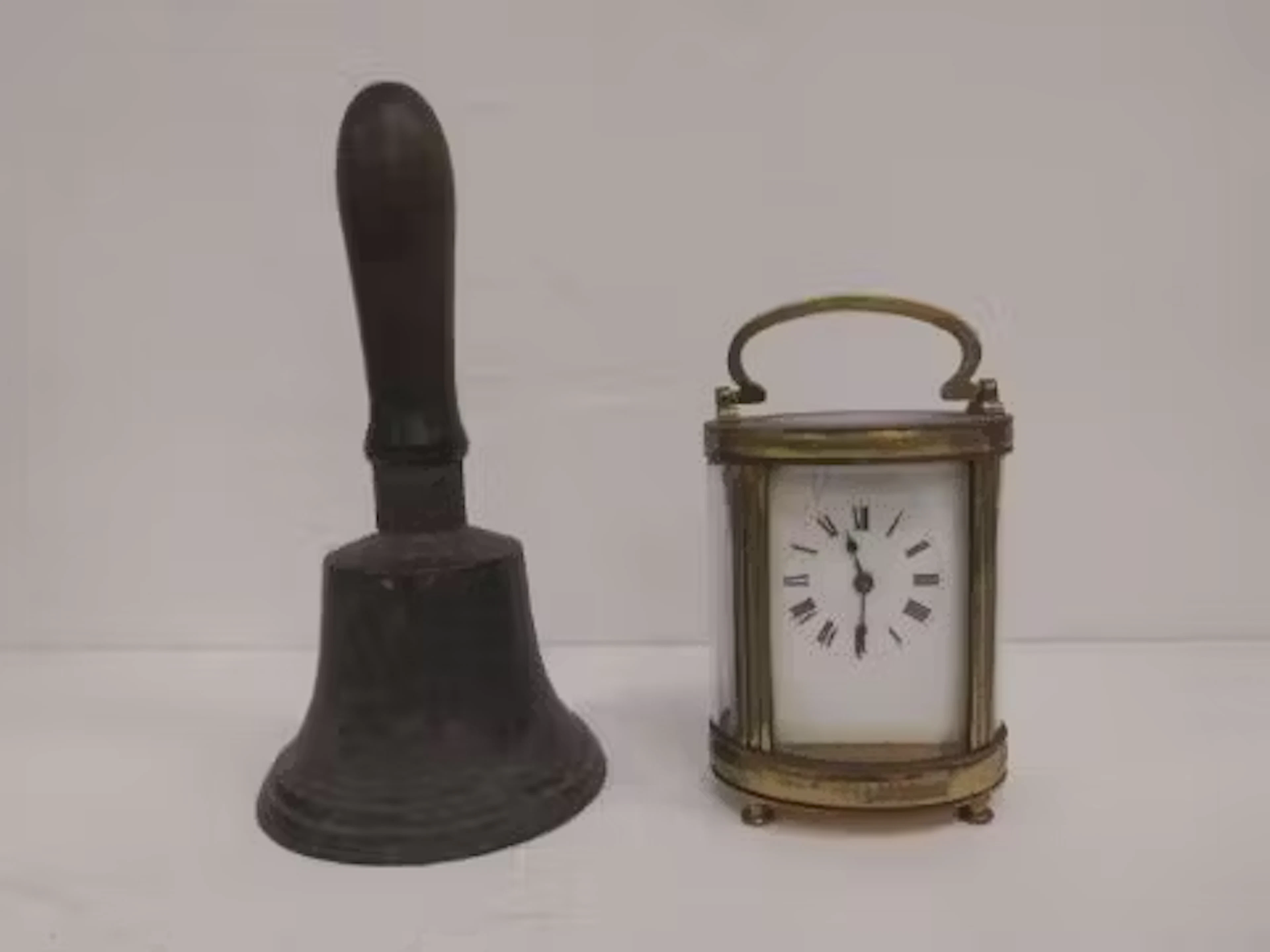 An 18th century bronze hand bell and a 19th century brass carriage