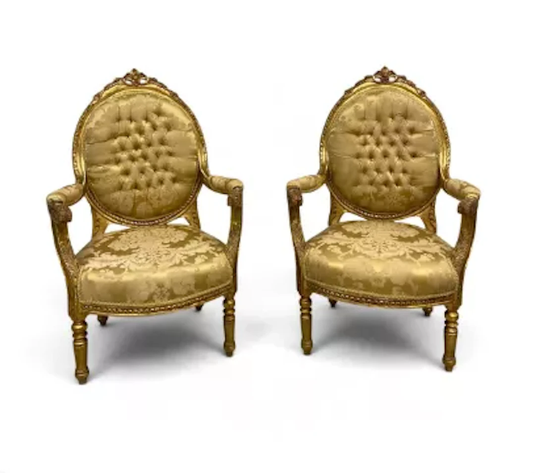 A pair of 19th century Louis XVI style carved giltwood open armchairs