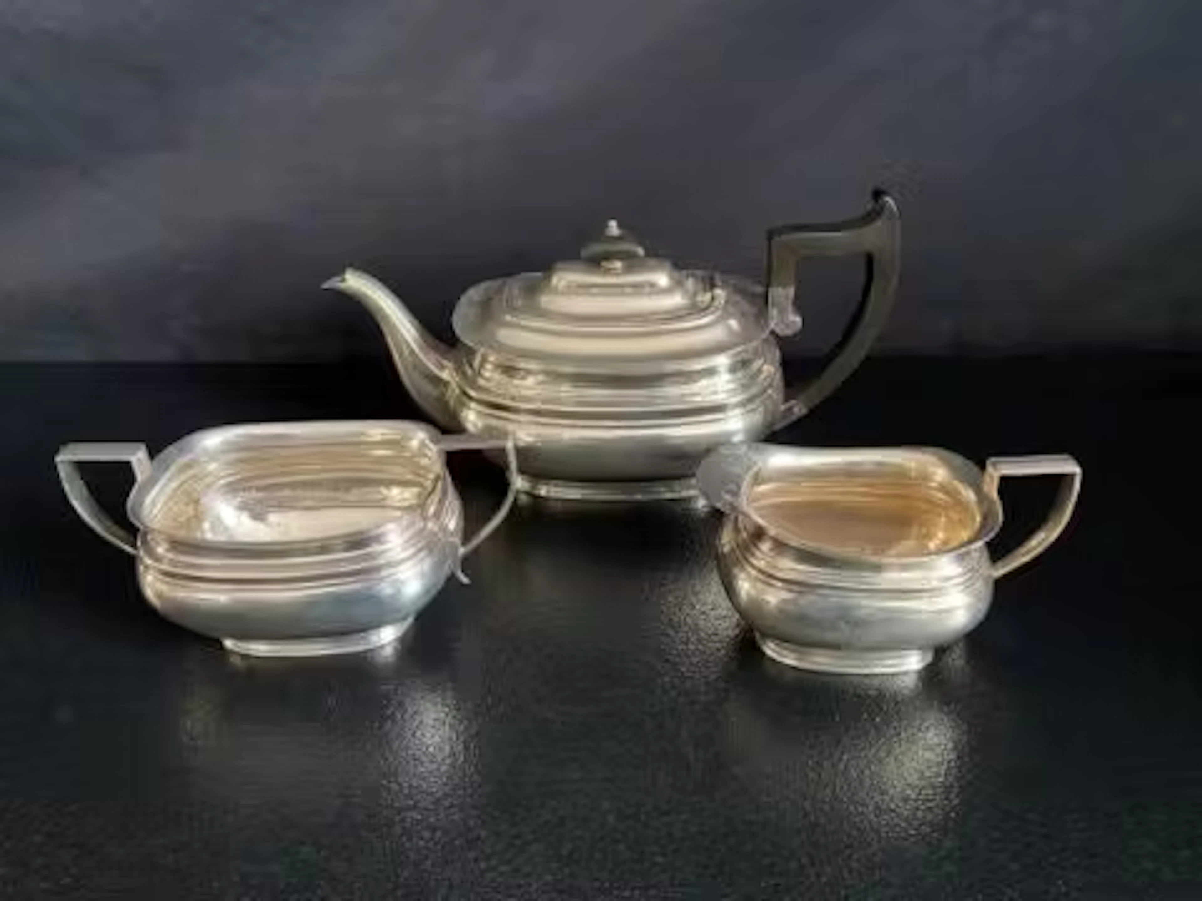 A three piece silver tea set; teapot, sugar bowl and milk jug, Roberts