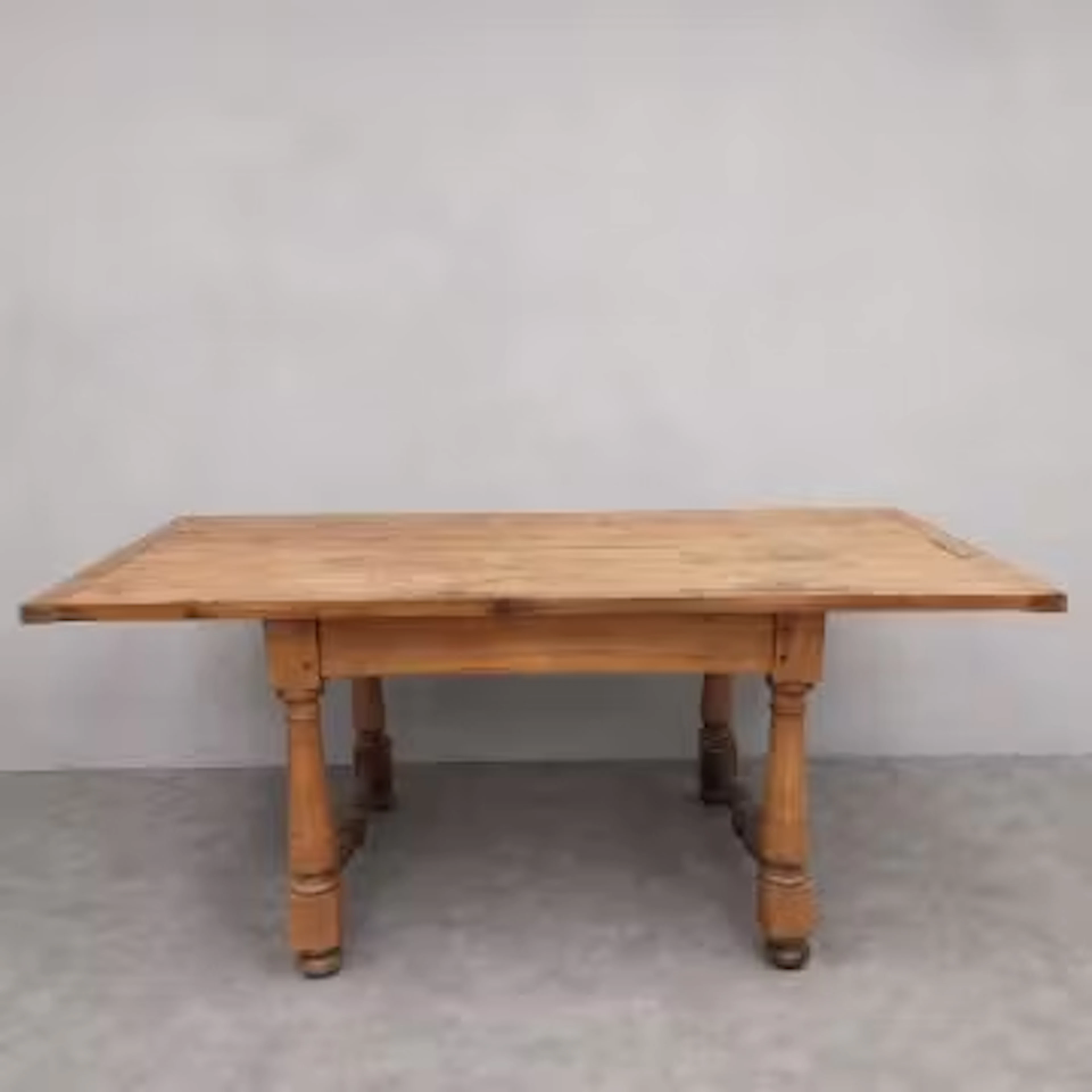 A late 19th century pine dining table with planked top with cleated