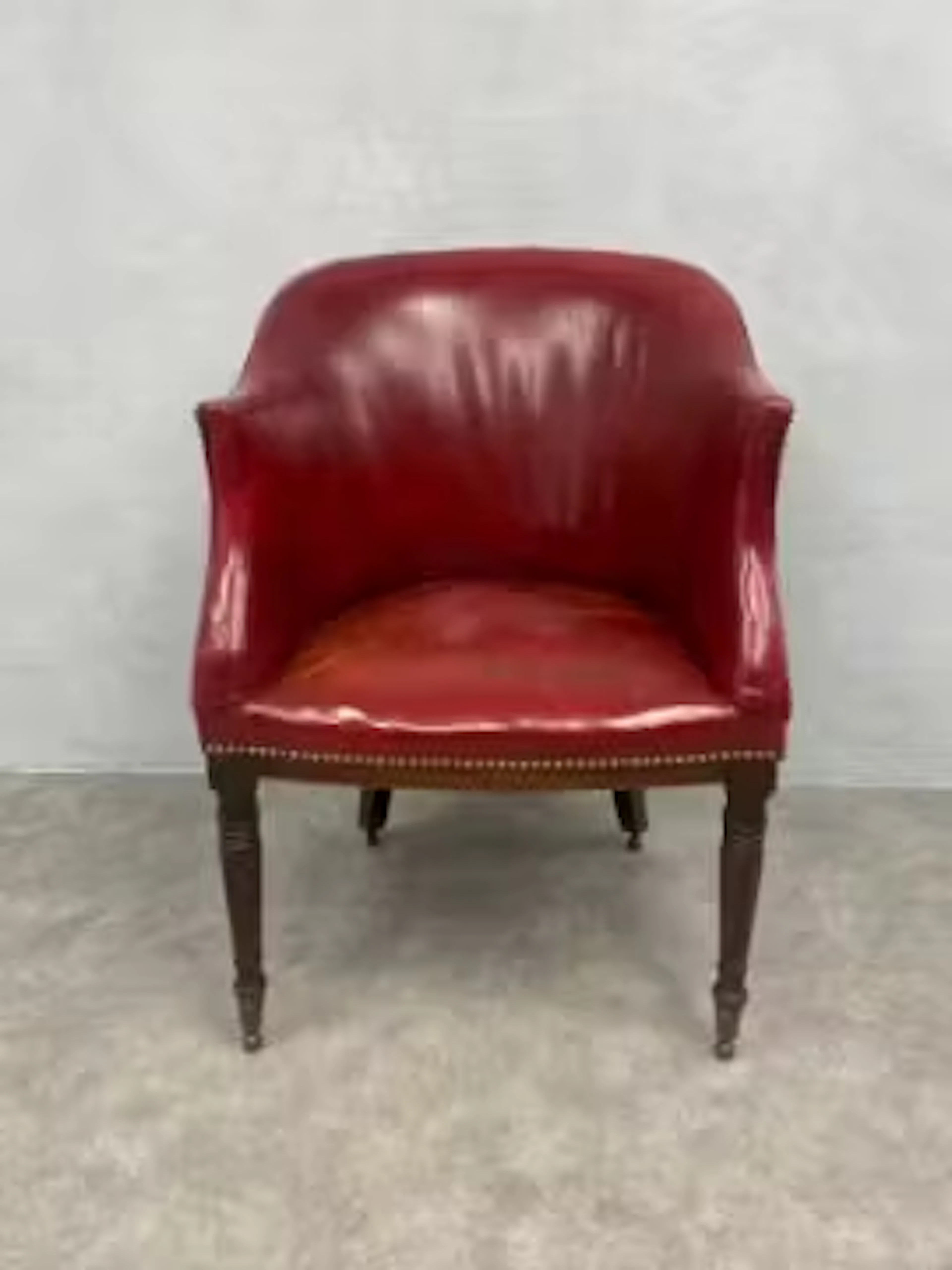 An early 19th century mahogany library tub armchair upholstered in