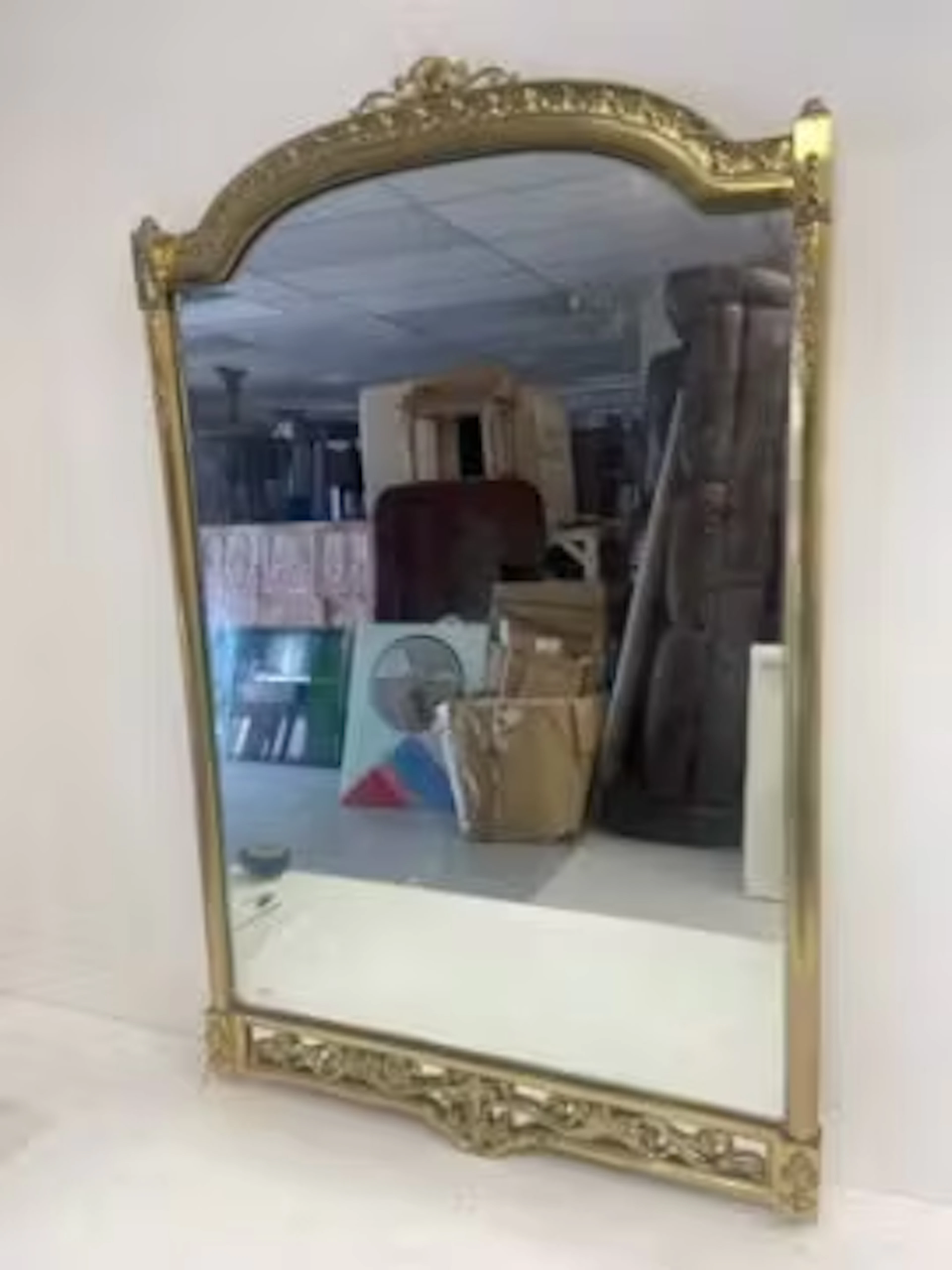 A vintage Italian wall mirror in heavy brass arched scrolling foliate