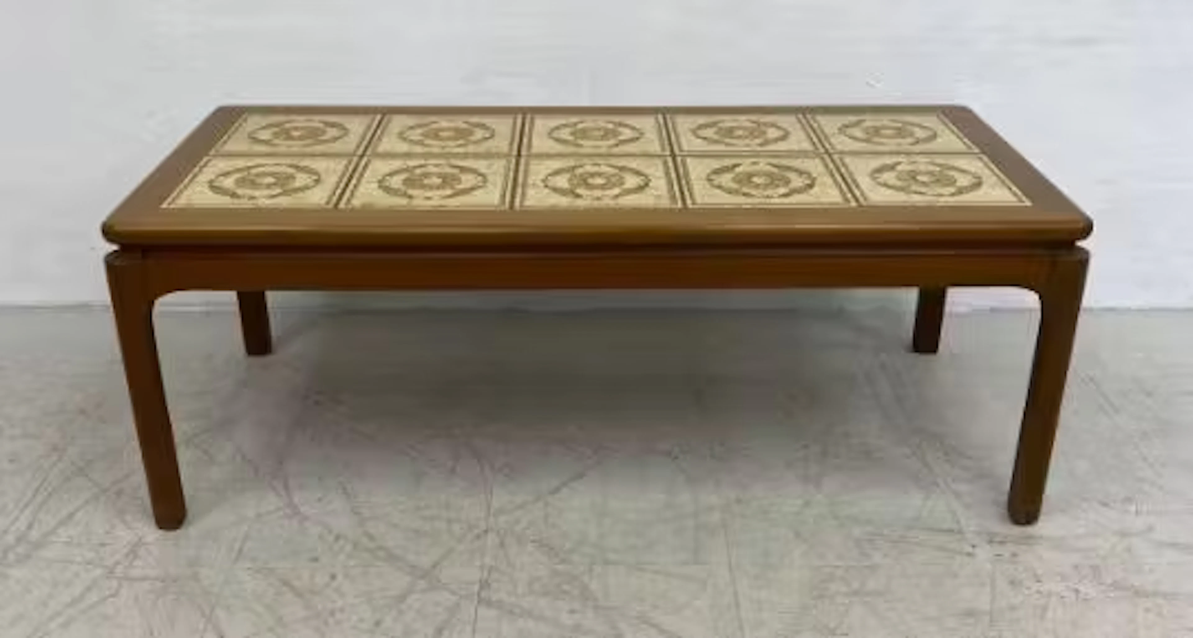 A mid century teak coffee table with inset ceramic tiled top. 42x113x52cm