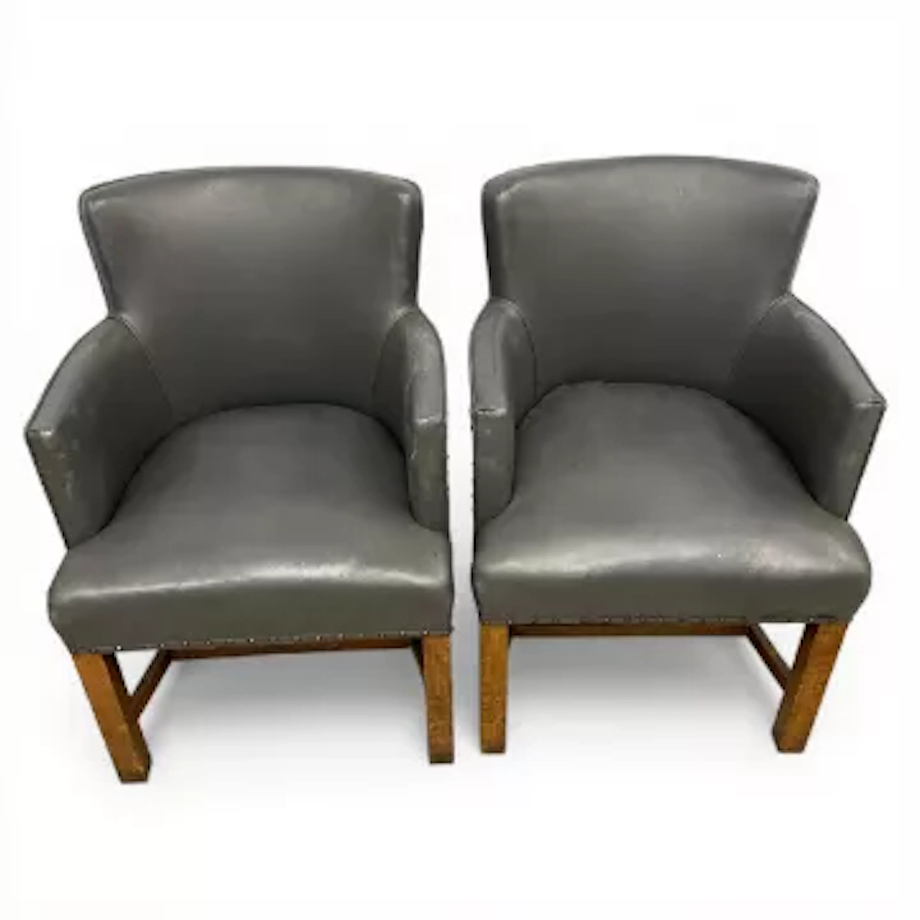A pair of vintage tub chairs each having a curved back and arms over