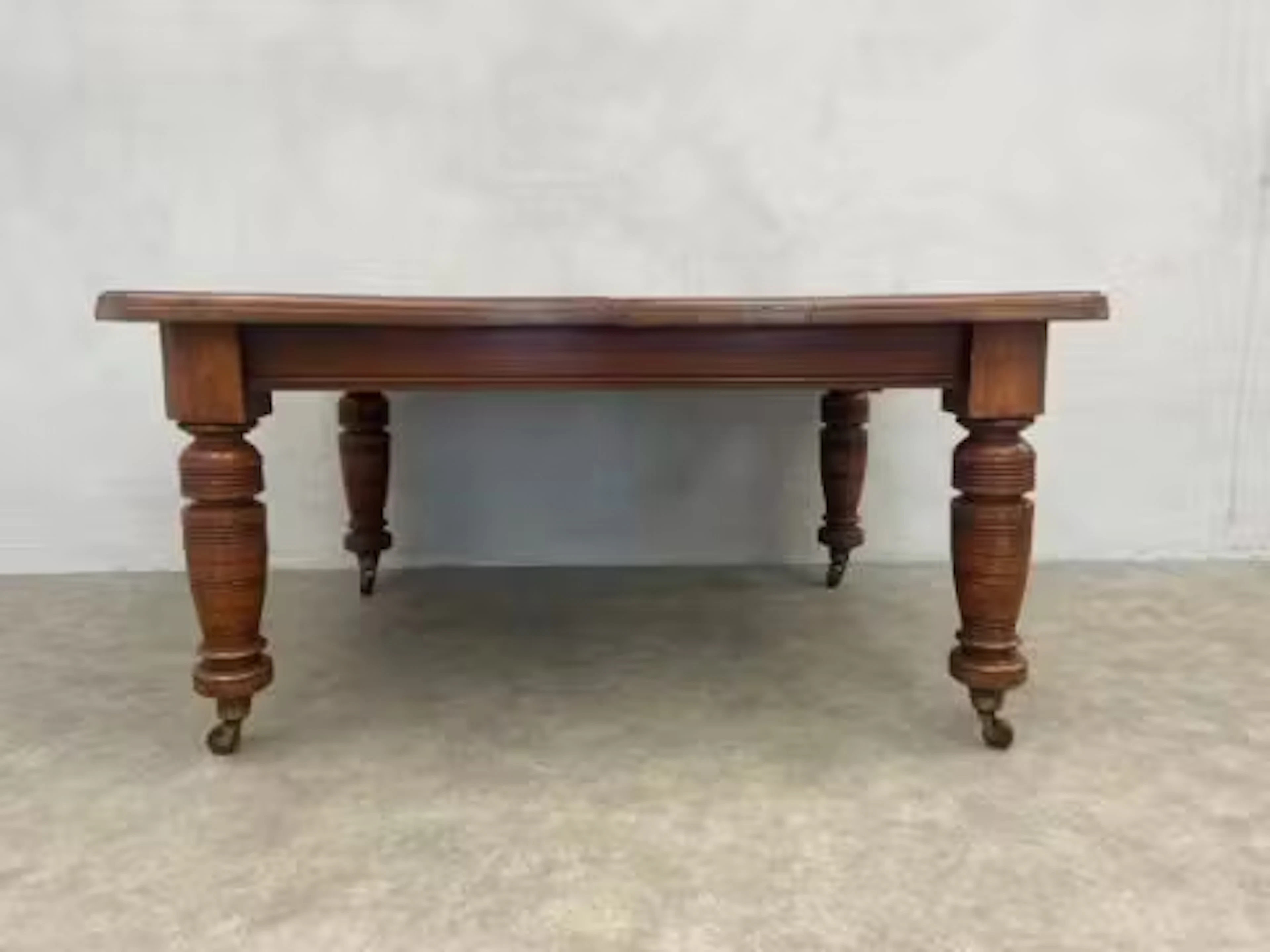 A late 19th century flame mahogany extending dining table with wind-out