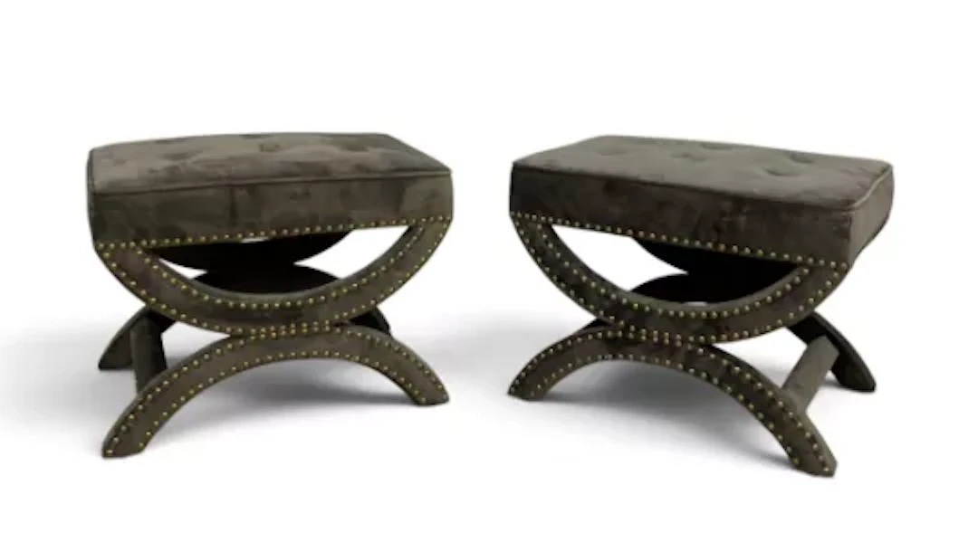 A pair of contemporary arched x-frame foot stools in deep buttoned