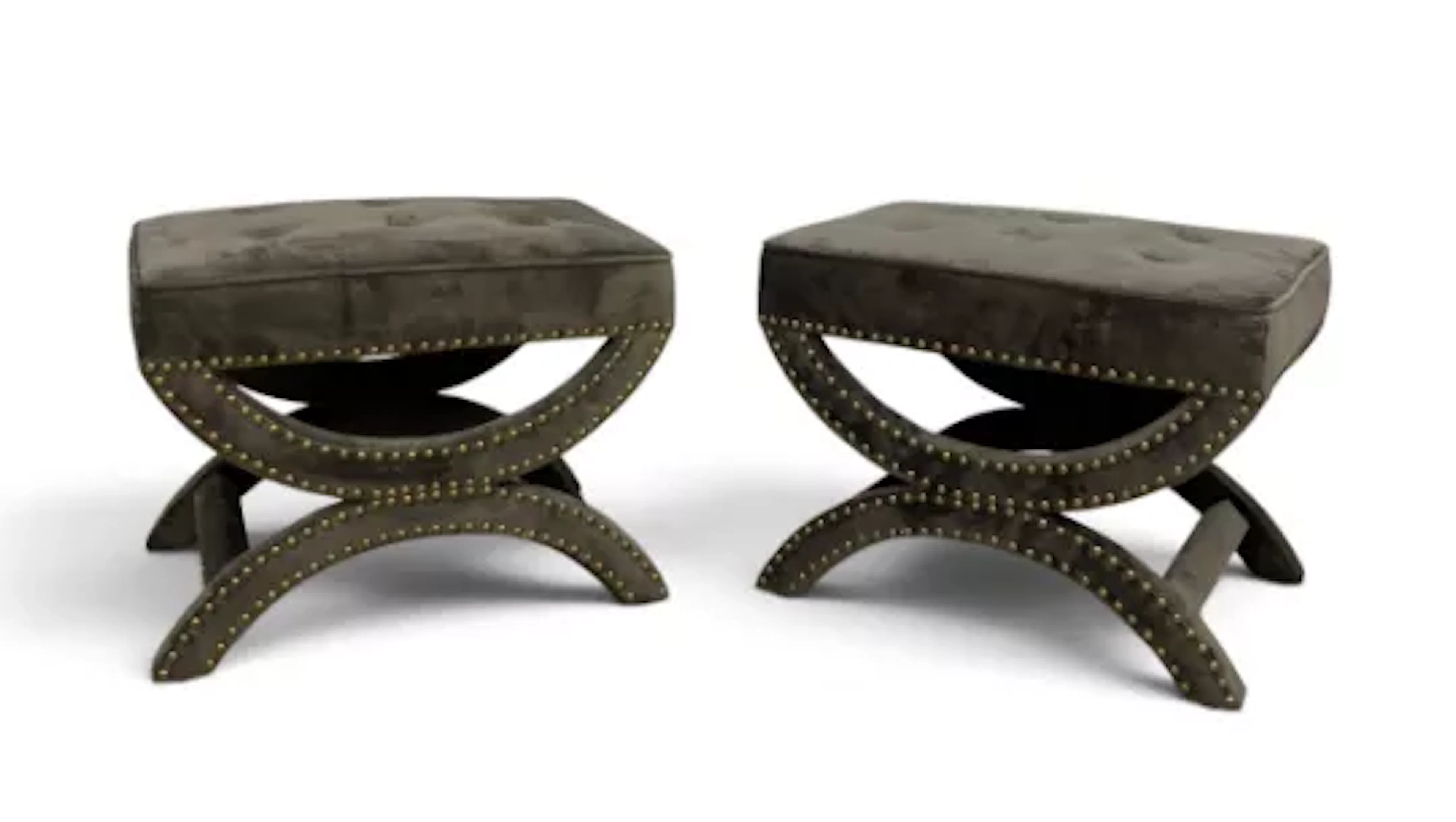 A pair of contemporary arched x-frame foot stools in deep buttoned