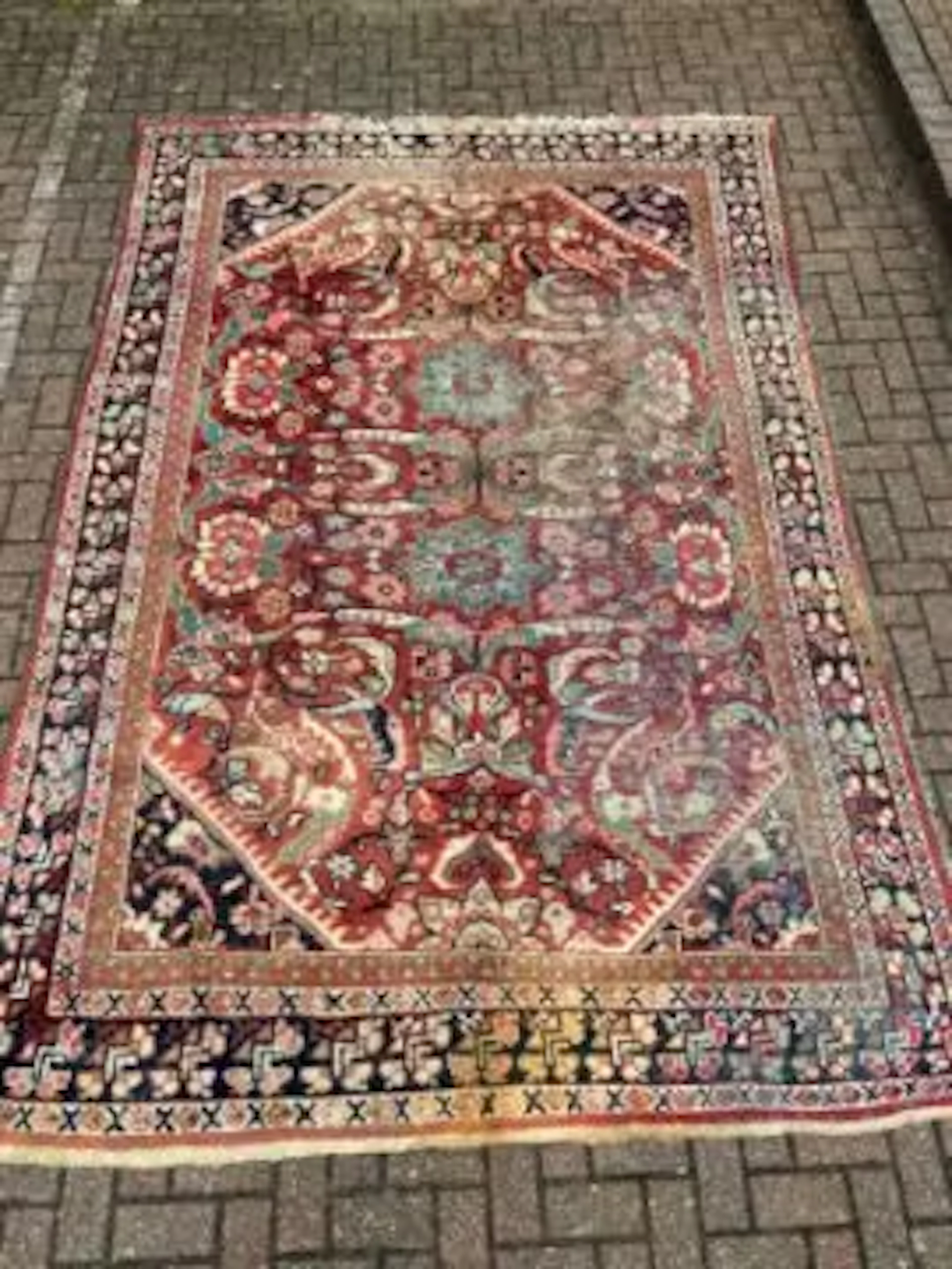 A hand knotted Heriz carpet with flowerhead medallions on a burgundy