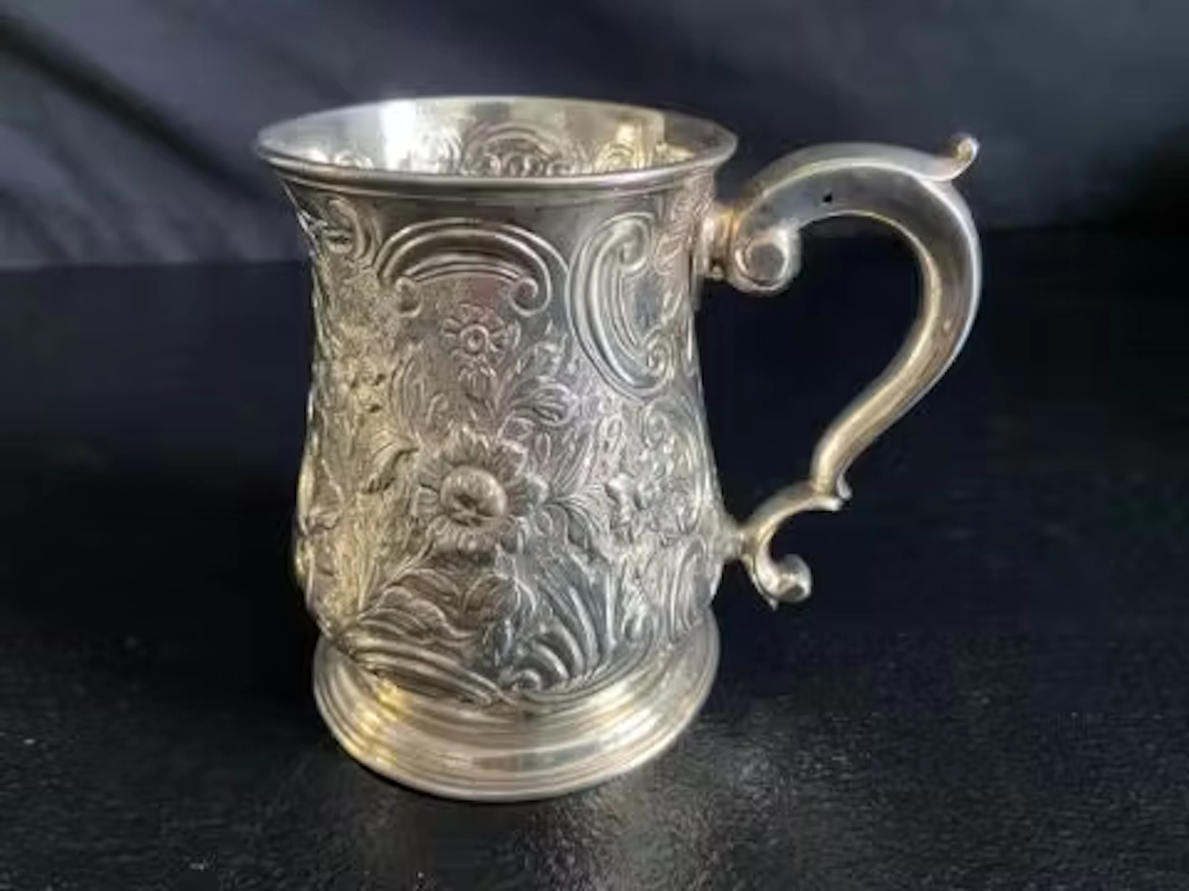 A silver tankard with allover embossed decoration, London hallmarks