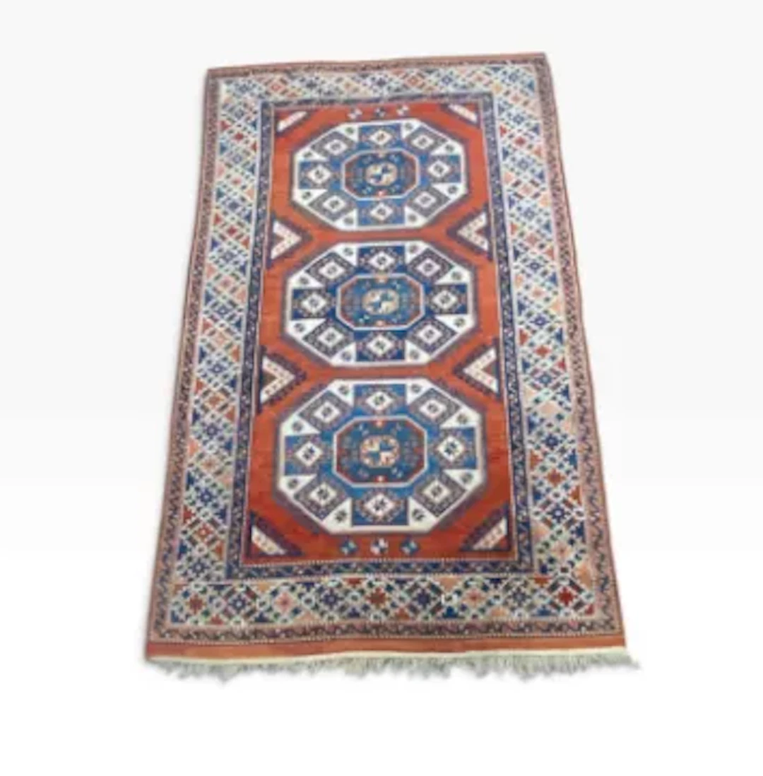 A hand knotted Shirvan style wool carpet with three octagonal lozenges