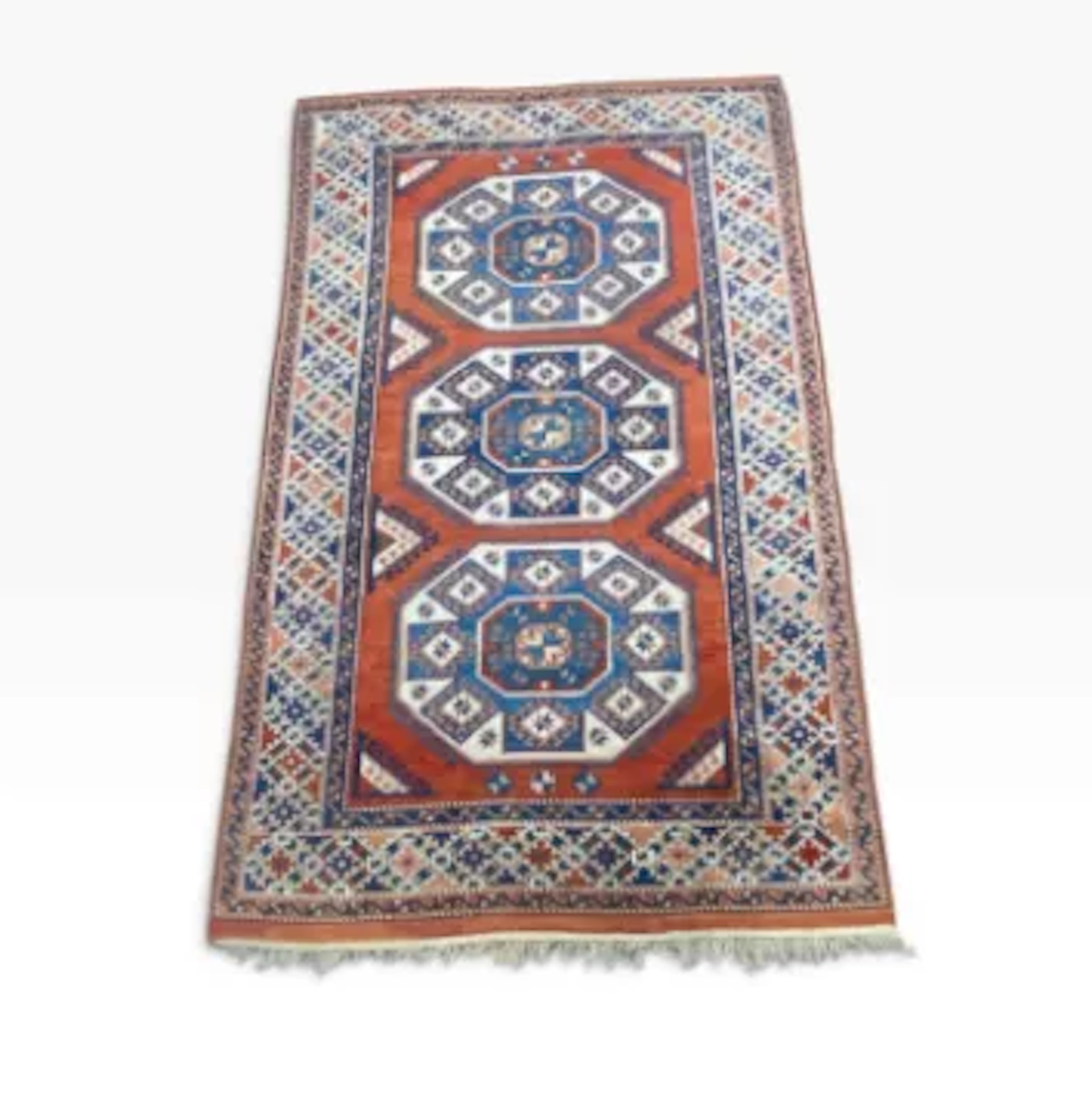 A hand knotted Shirvan style wool carpet with three octagonal lozenges