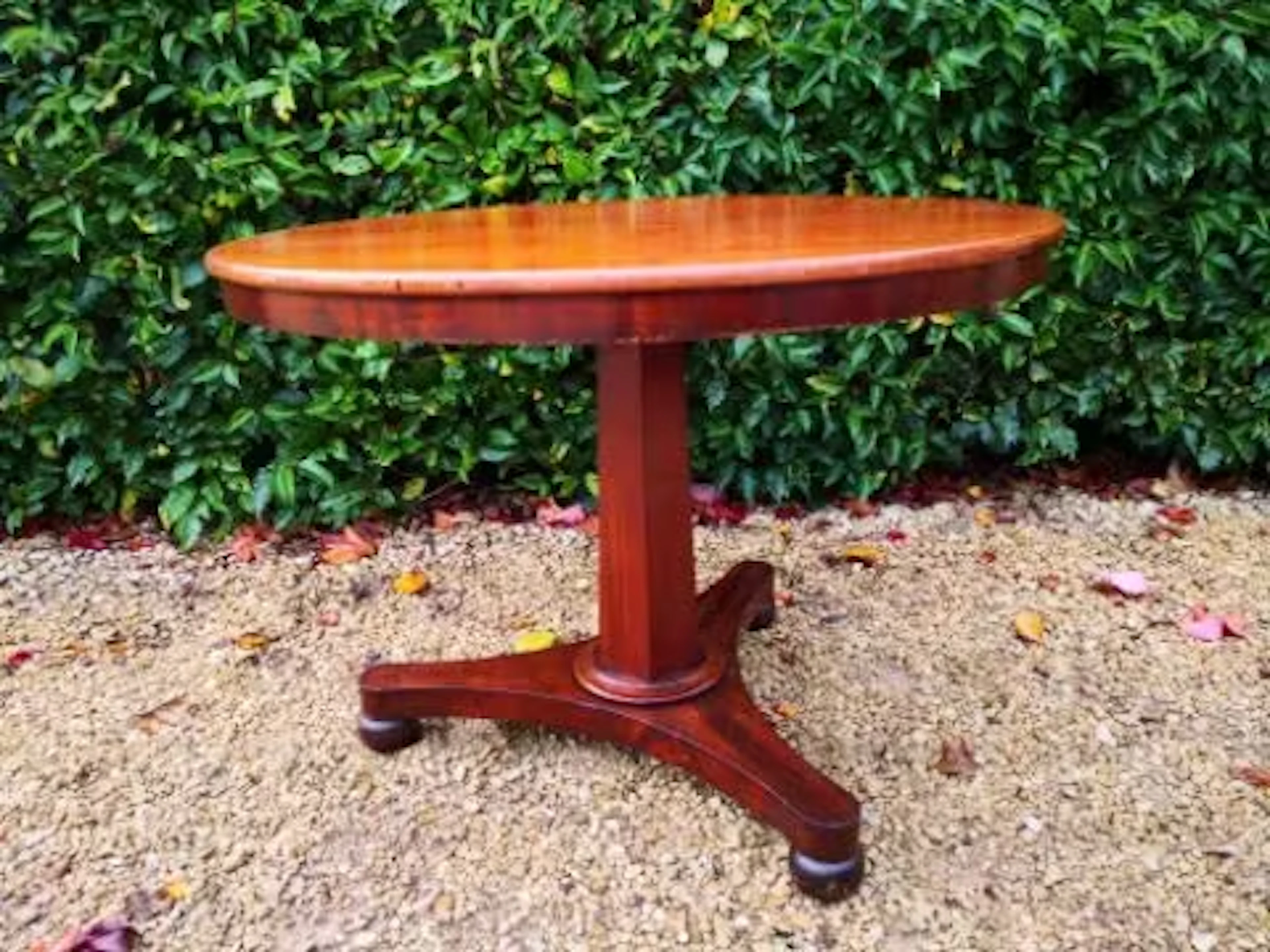 A mid 19th century mahogany tilt top dining table on triform pedestal