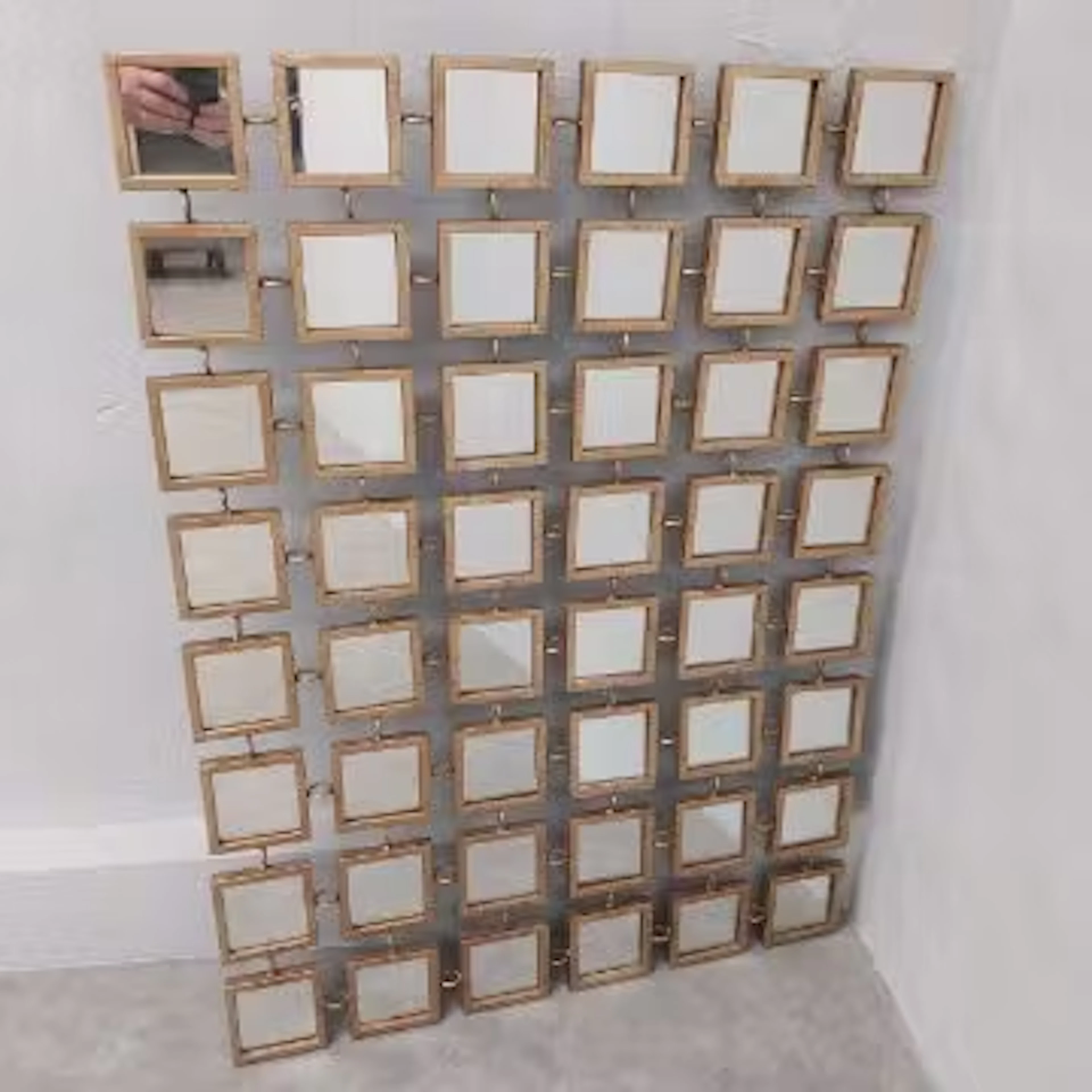 A contemporary gilt metal wall mirror of glazed sections connected