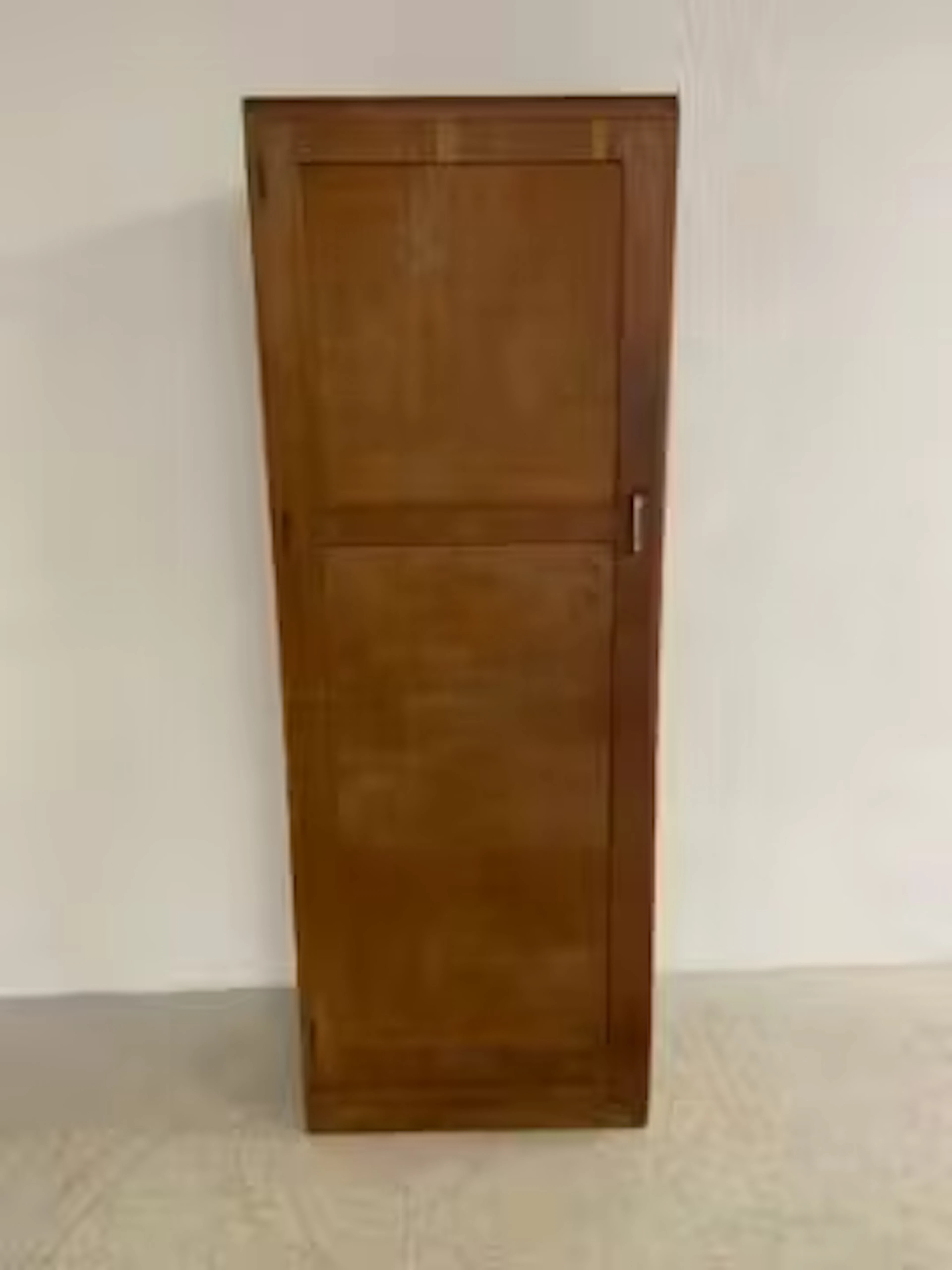 A mid-century oak wardrobe with single panelled door enclosing hanging