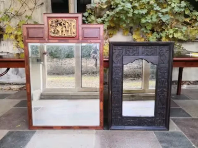 A Chinese teak framed mirror with gilt carved pediment and bevelled