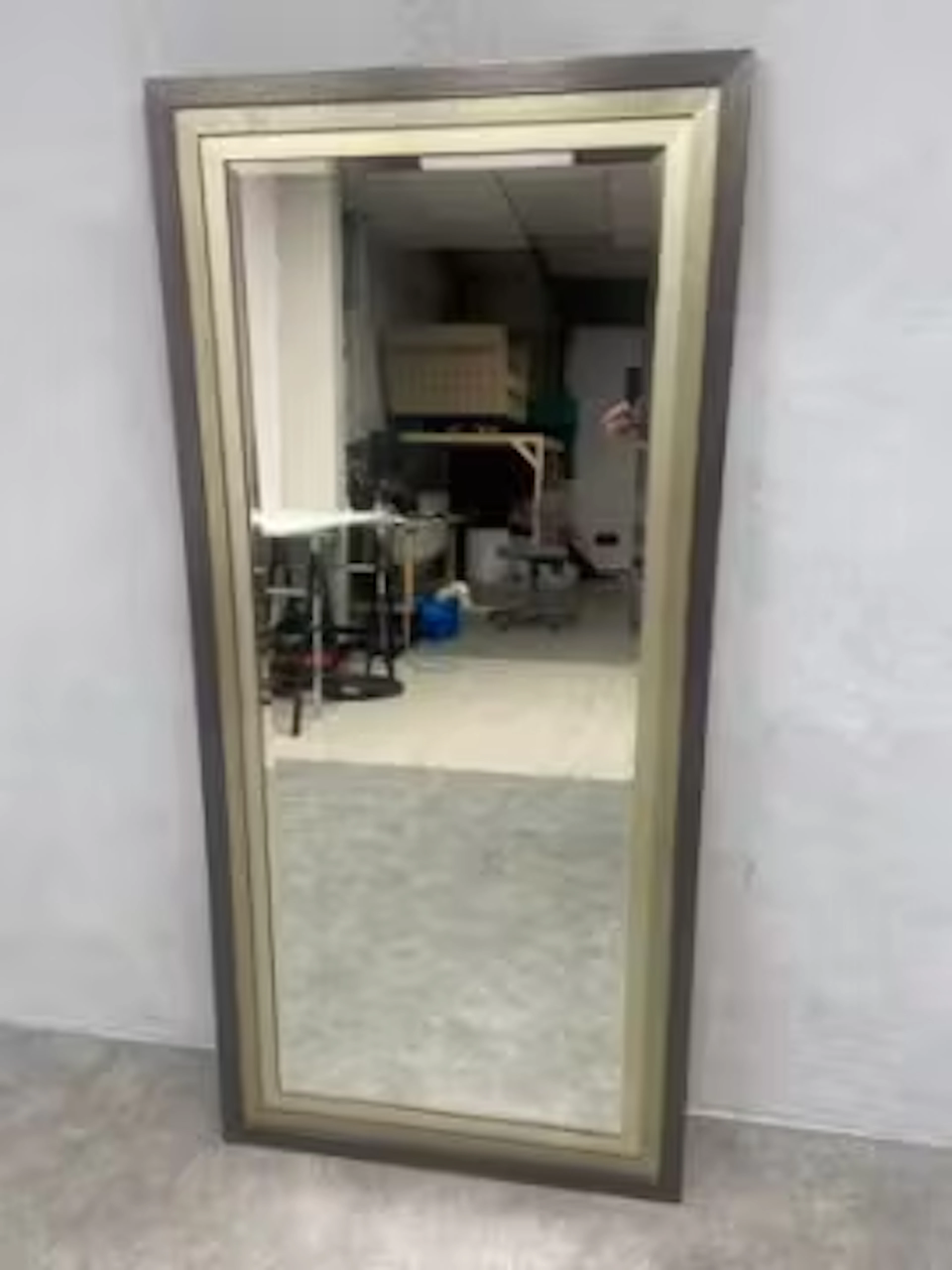 A contemporary dressing mirror in a stepped painted frame with bevelled