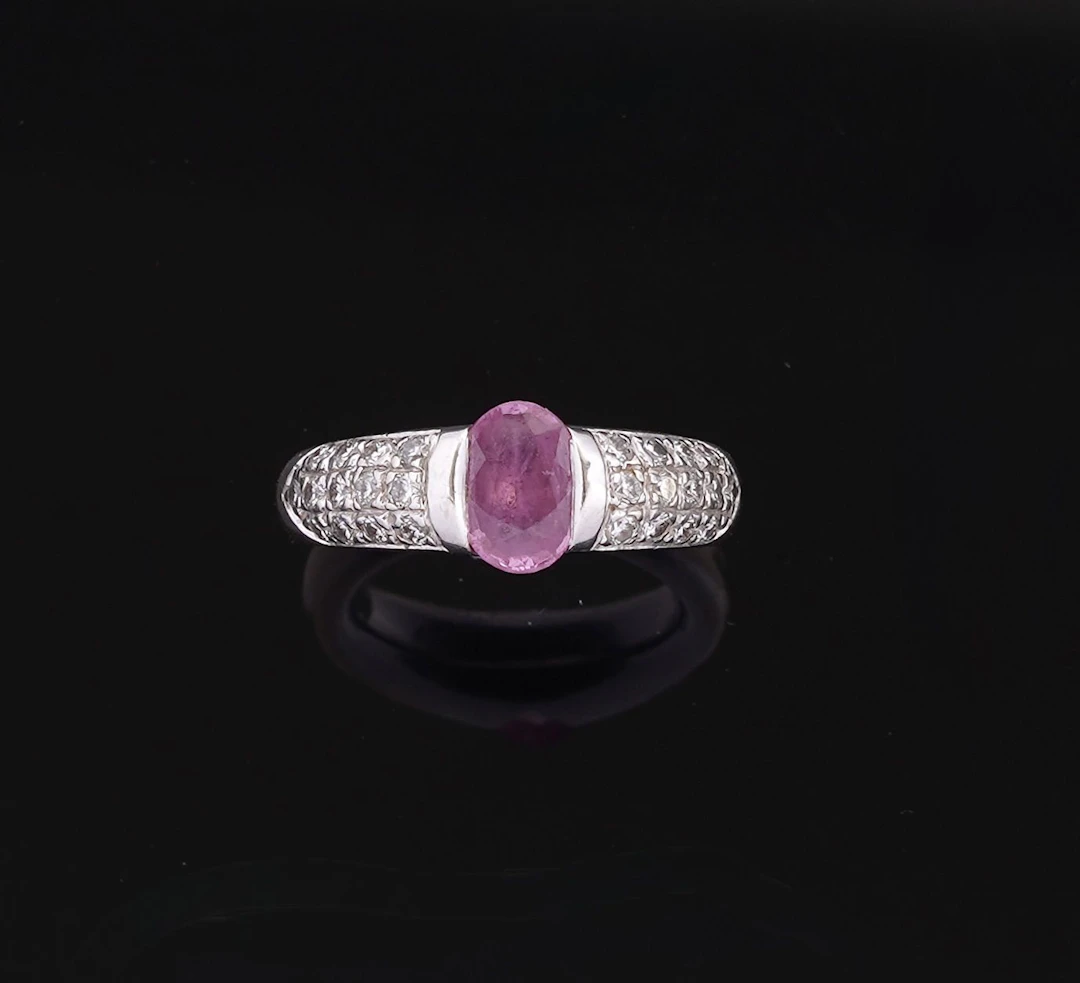 An 18k white gold (750) band ring set with an oval-cut pink - Lot 222