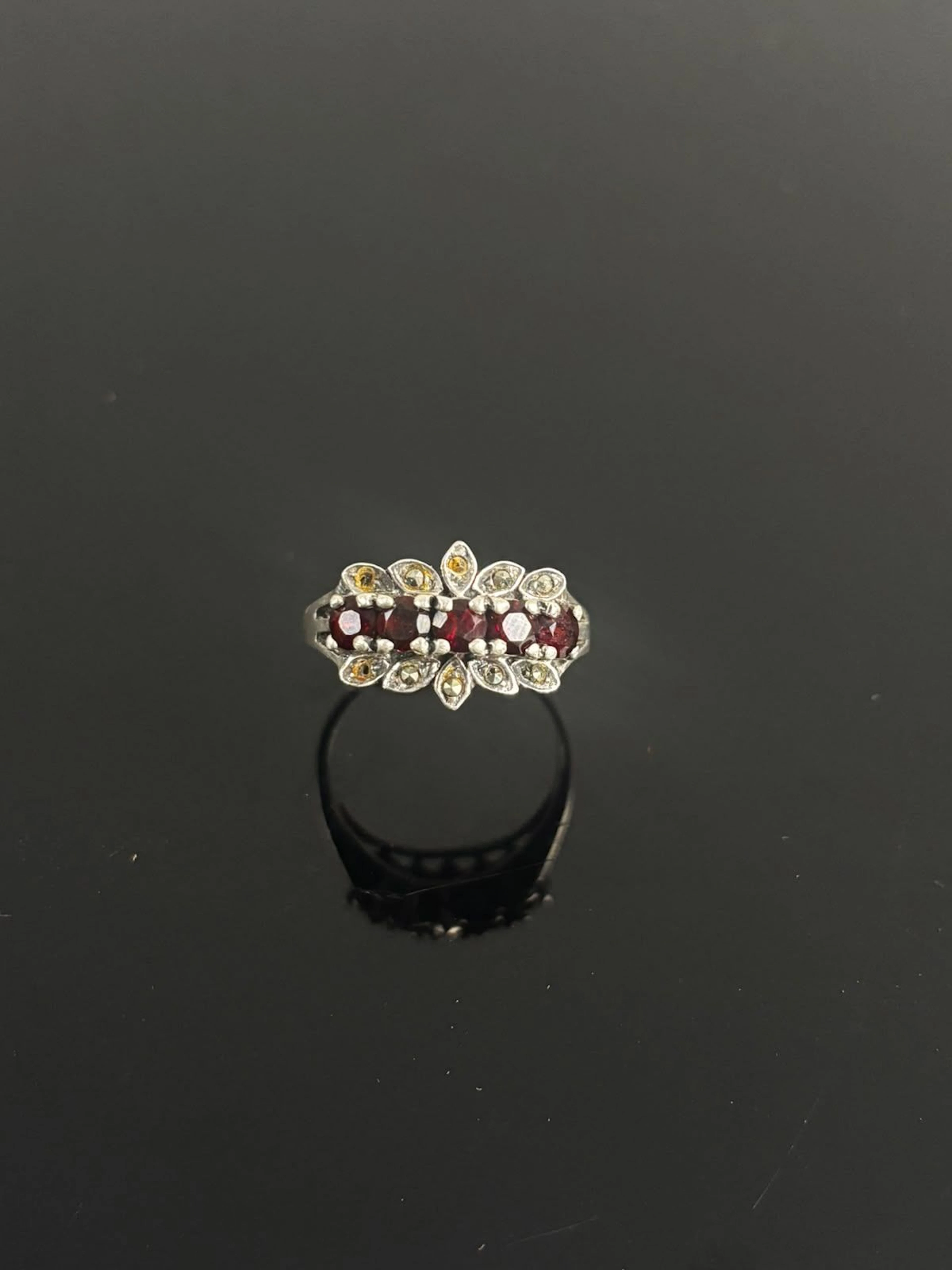 NV Silver ring set with a row of red stones flanked by white - Lot 175