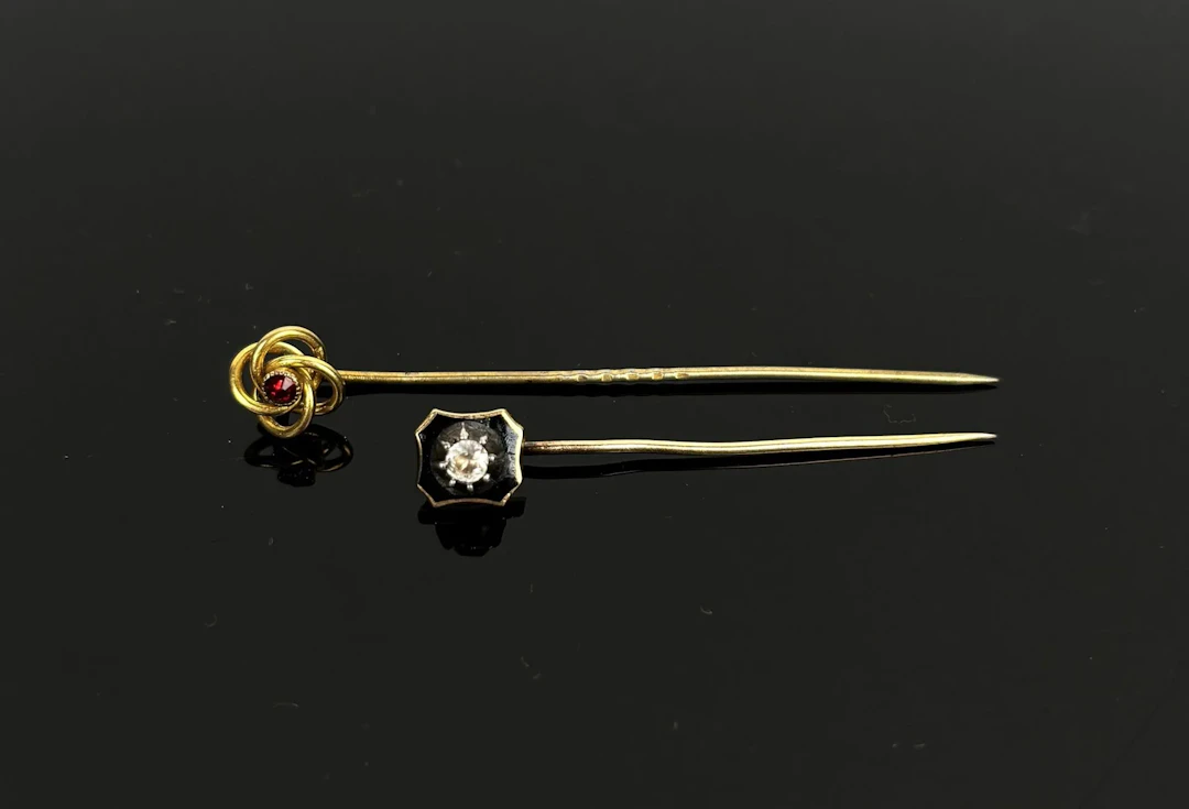 Set of two 9k 375 gold tie pins: one featuring an interlaced - Lot 176