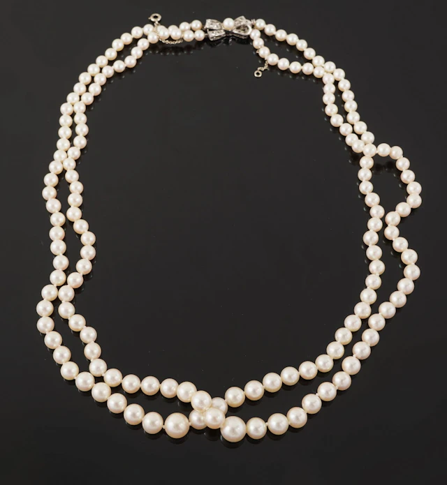 A necklace featuring two rows of cascading cultured pearls, - Lot 102