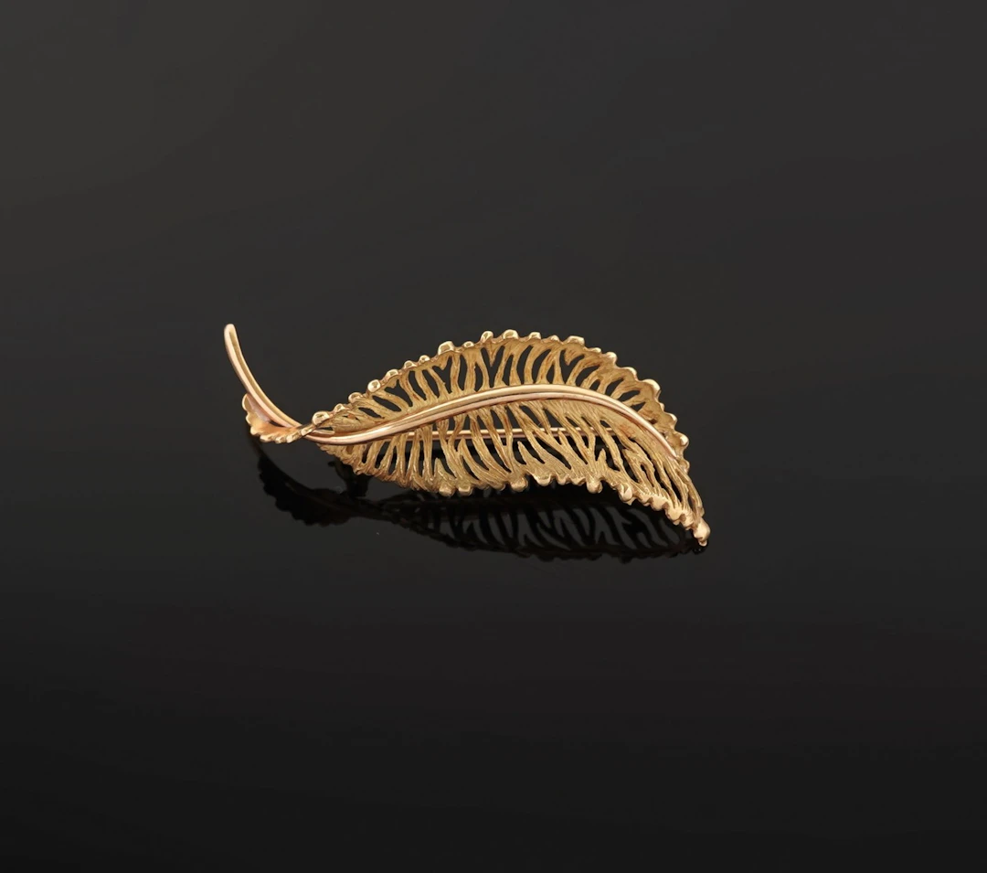 An 18k yellow gold brooch (750 parts per thousand) shaped li - Lot 101