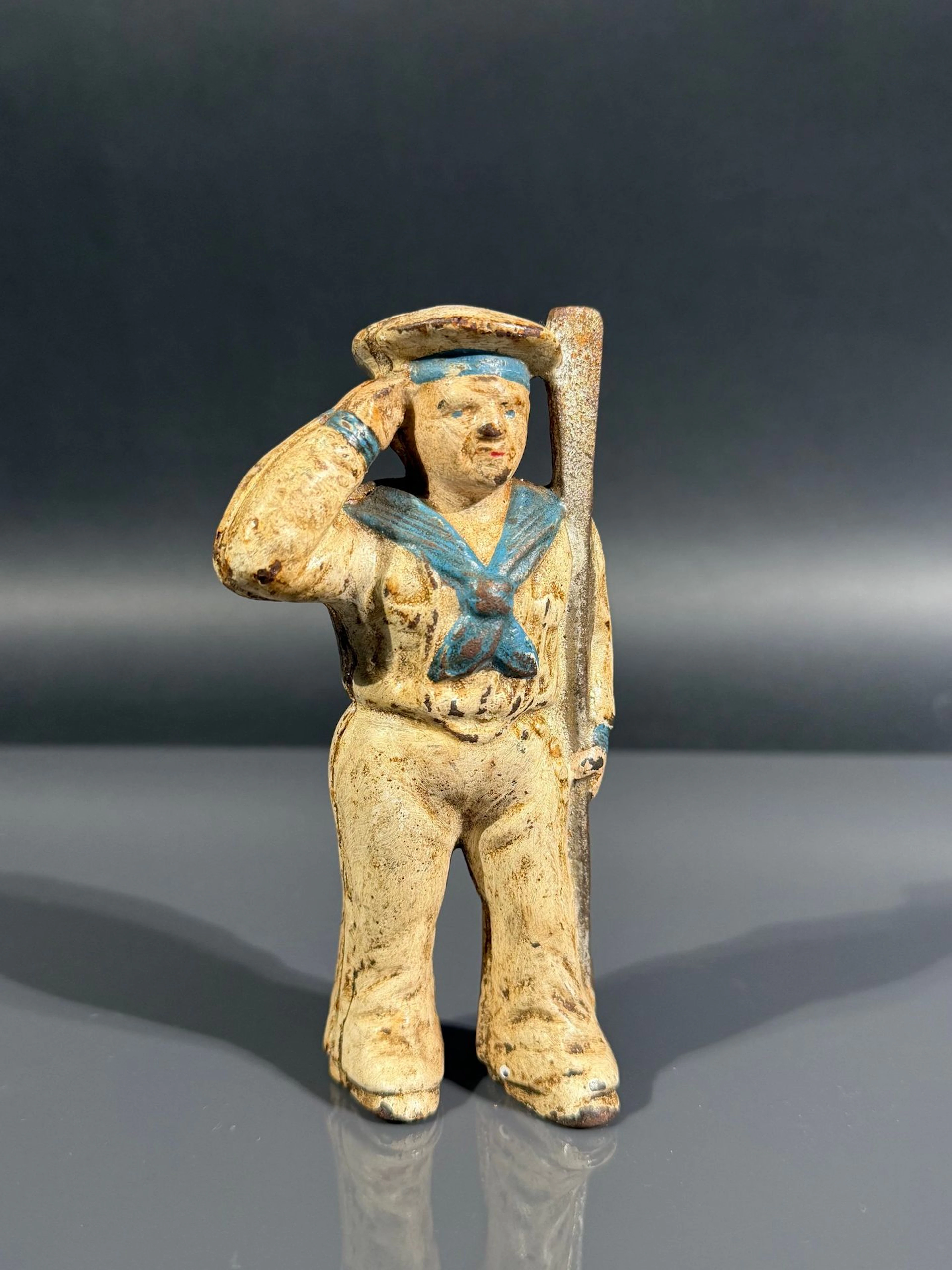 Antique cast-iron piggy bank depicting a sailor with a paddl - Lot 274