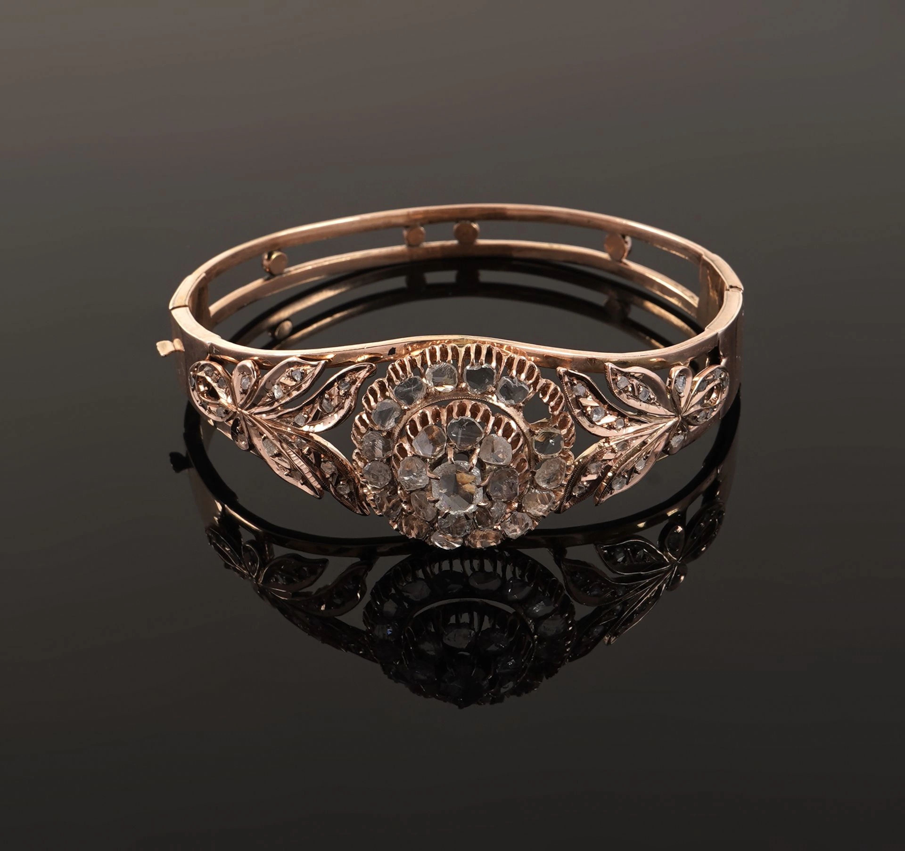 A 14k gold (585) clasp-style bangle featuring a circular rel - Lot 155