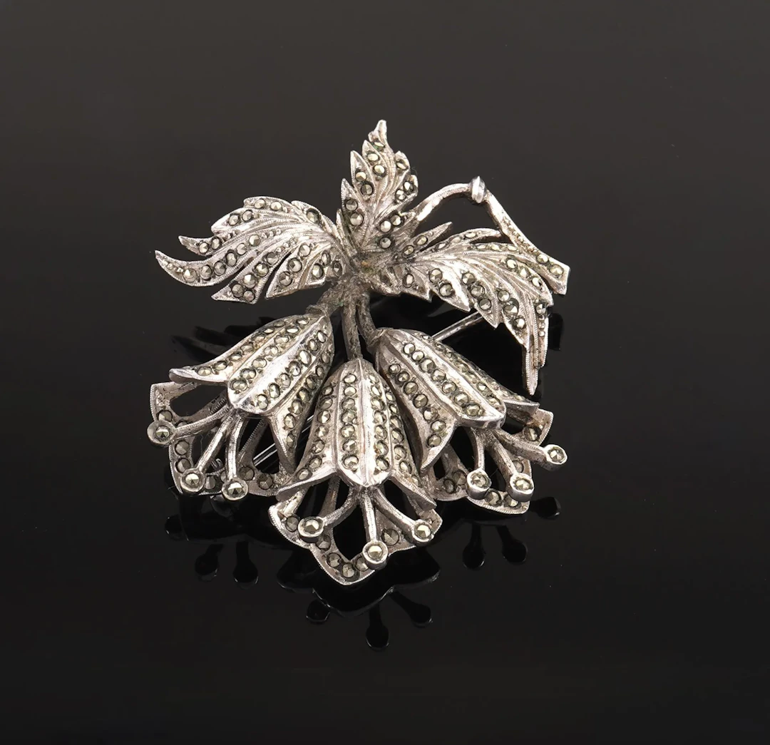 A silver plated brooch featuring three stylized blooming flo - Lot 72