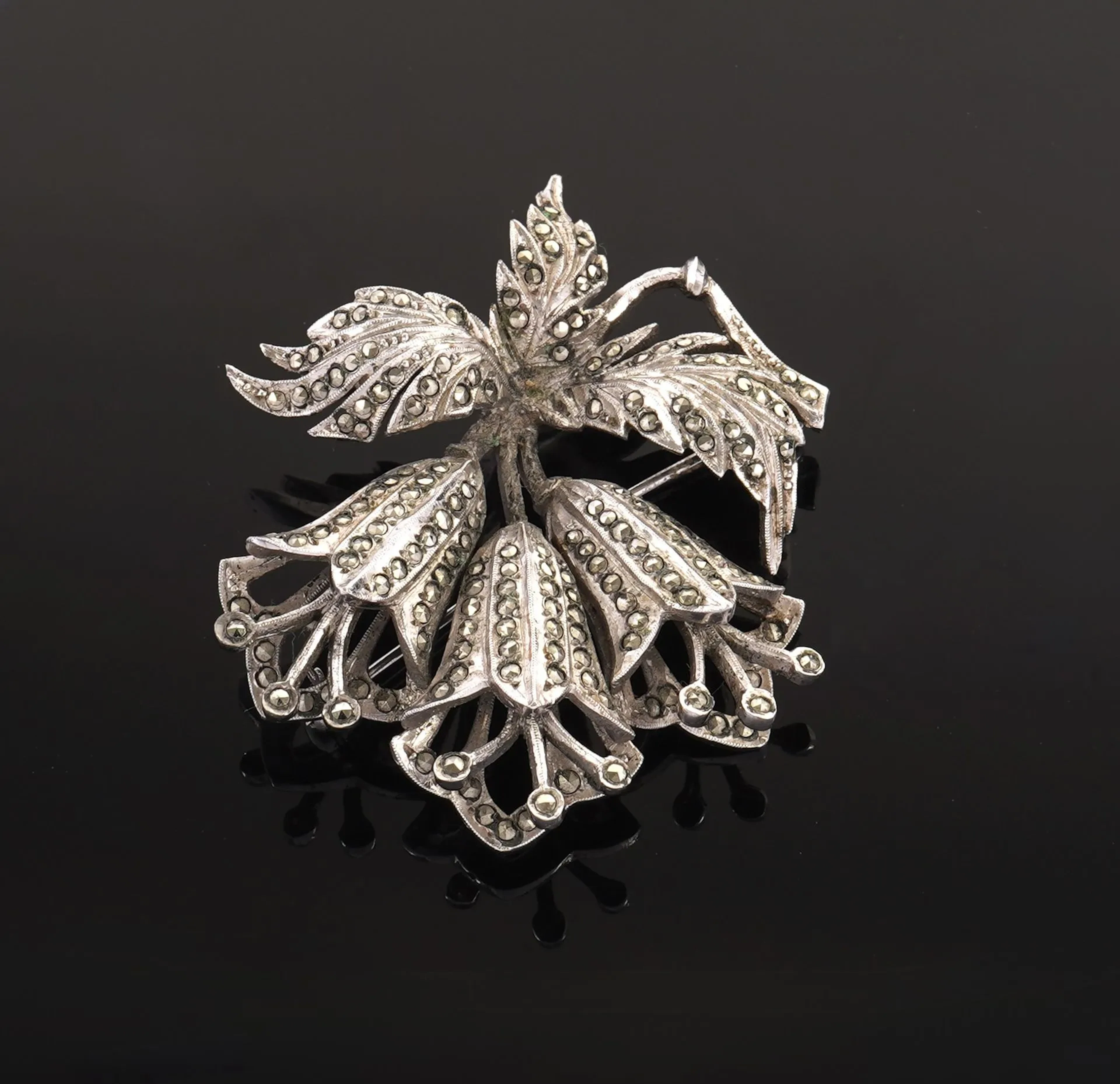 A silver plated brooch featuring three stylized blooming flo - Lot 72
