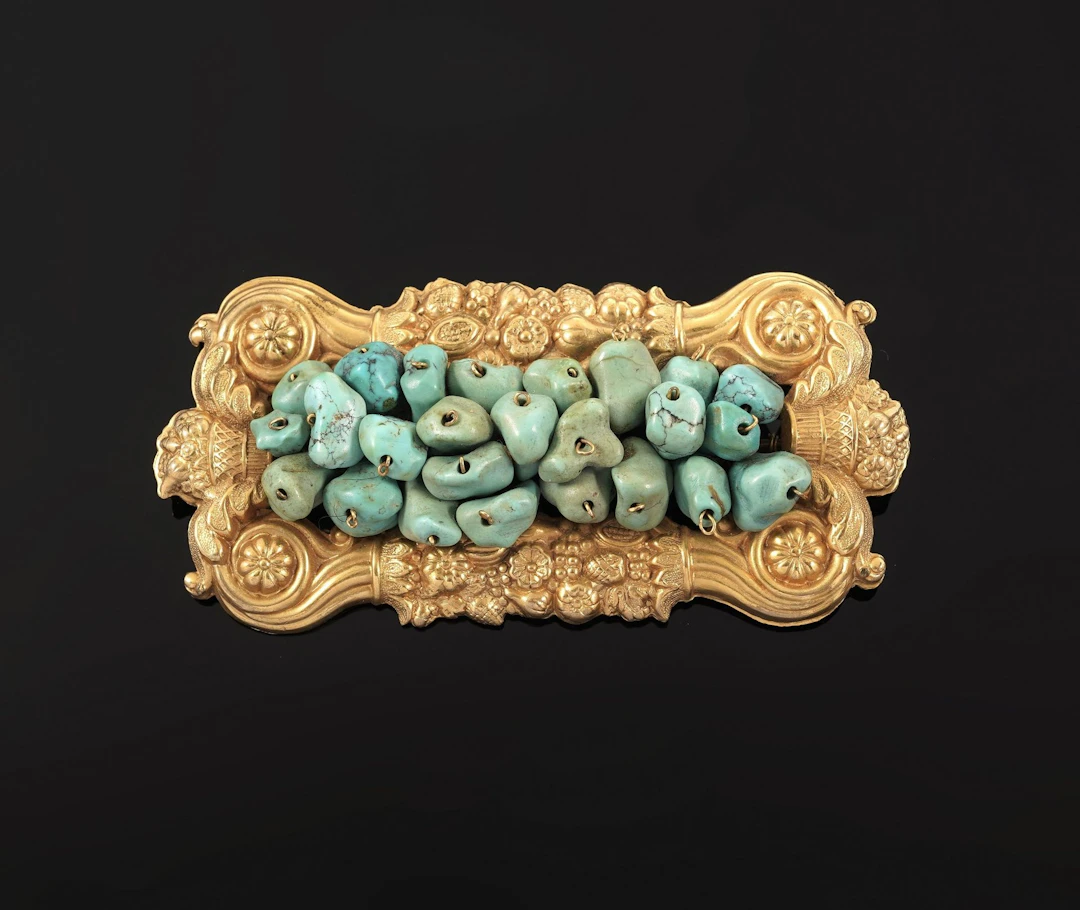 A rectangular gold-plated metal brooch richly decorated with - Lot 58