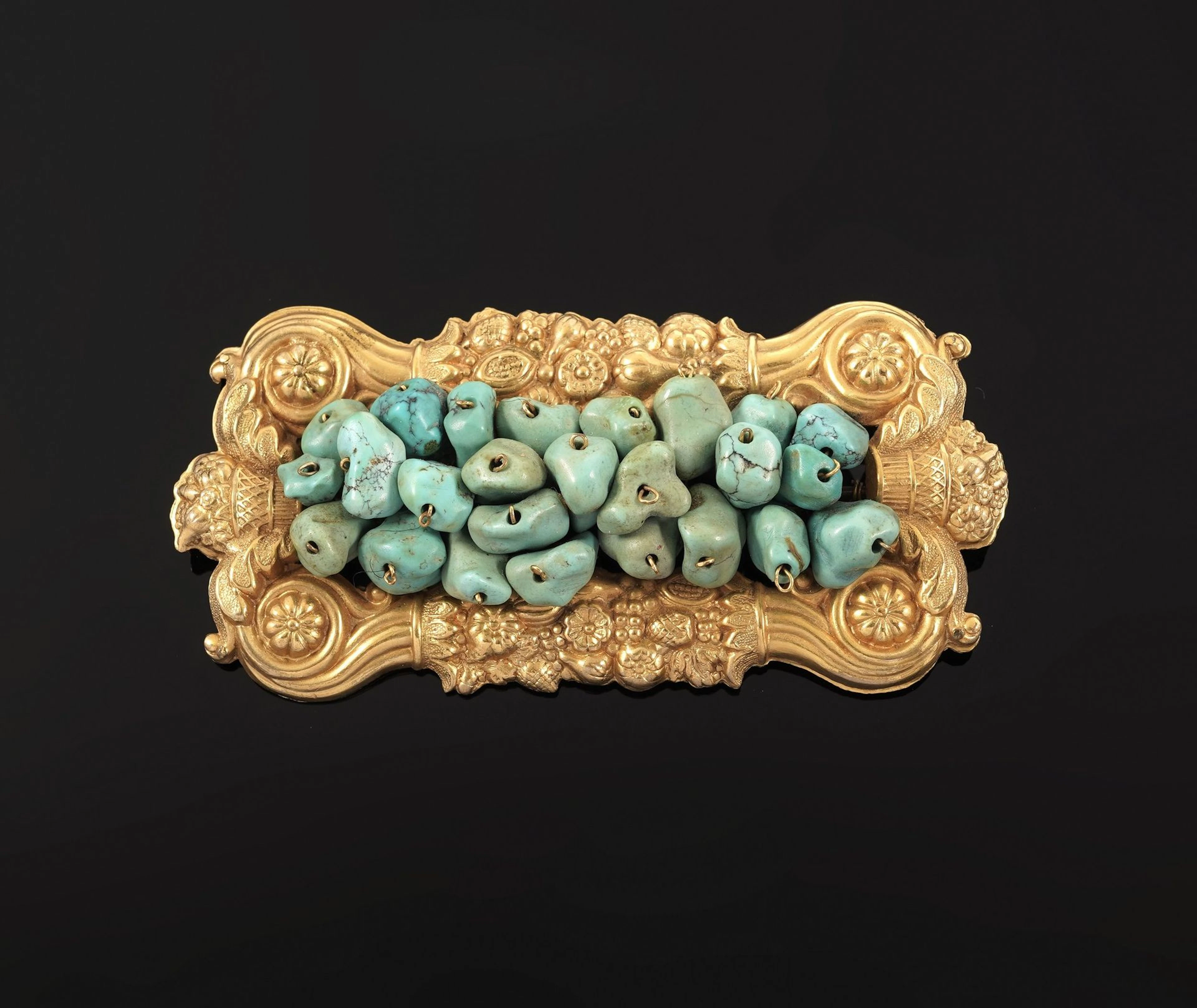 A rectangular gold-plated metal brooch richly decorated with - Lot 58