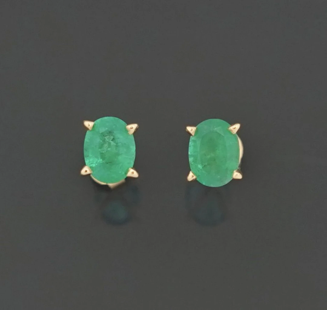 Pair of 14k yellow gold stud earrings, set with oval-cut eme - Lot 339
