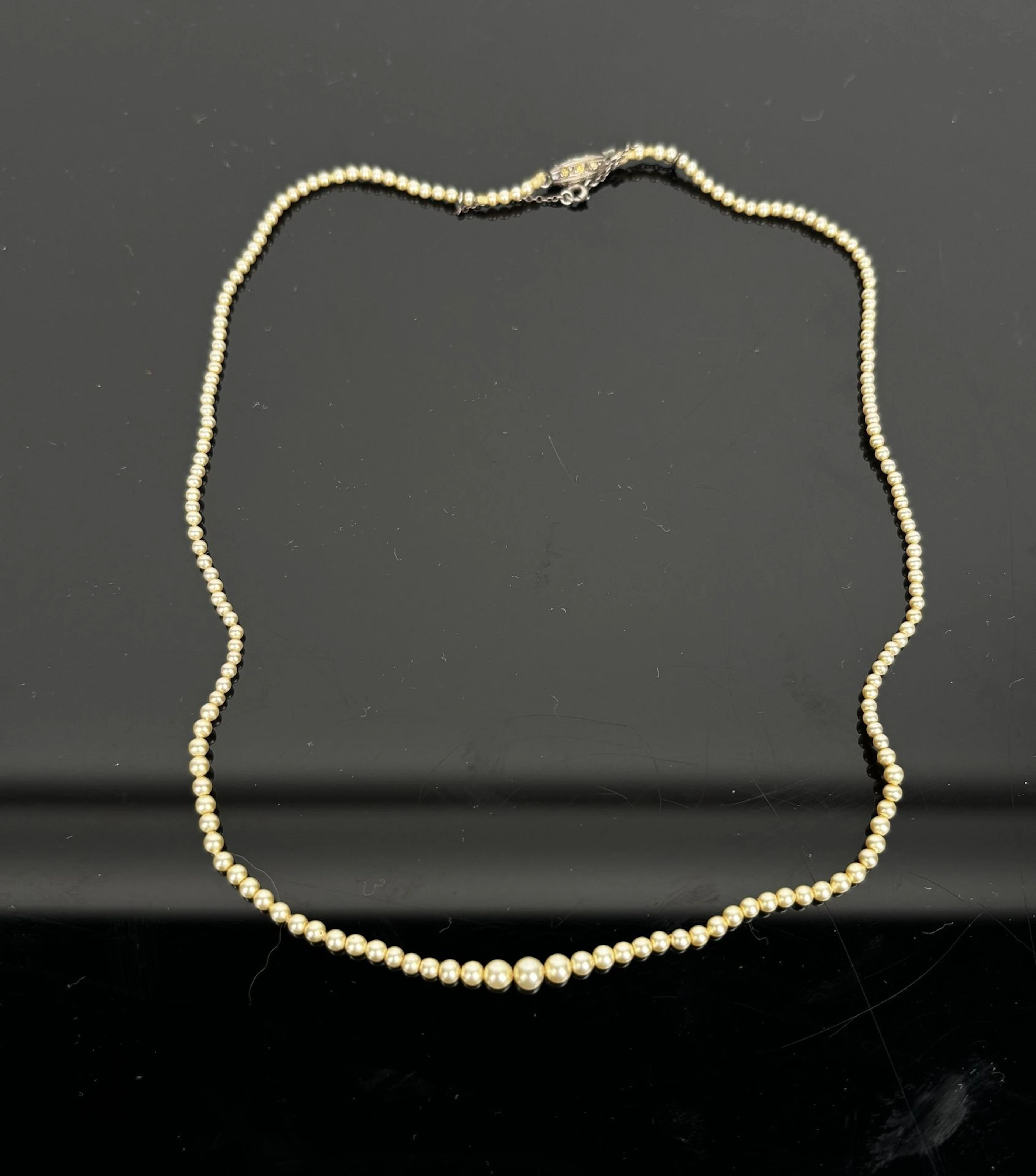 A necklace featuring small, cascading cultured pearls. The c - Lot 169