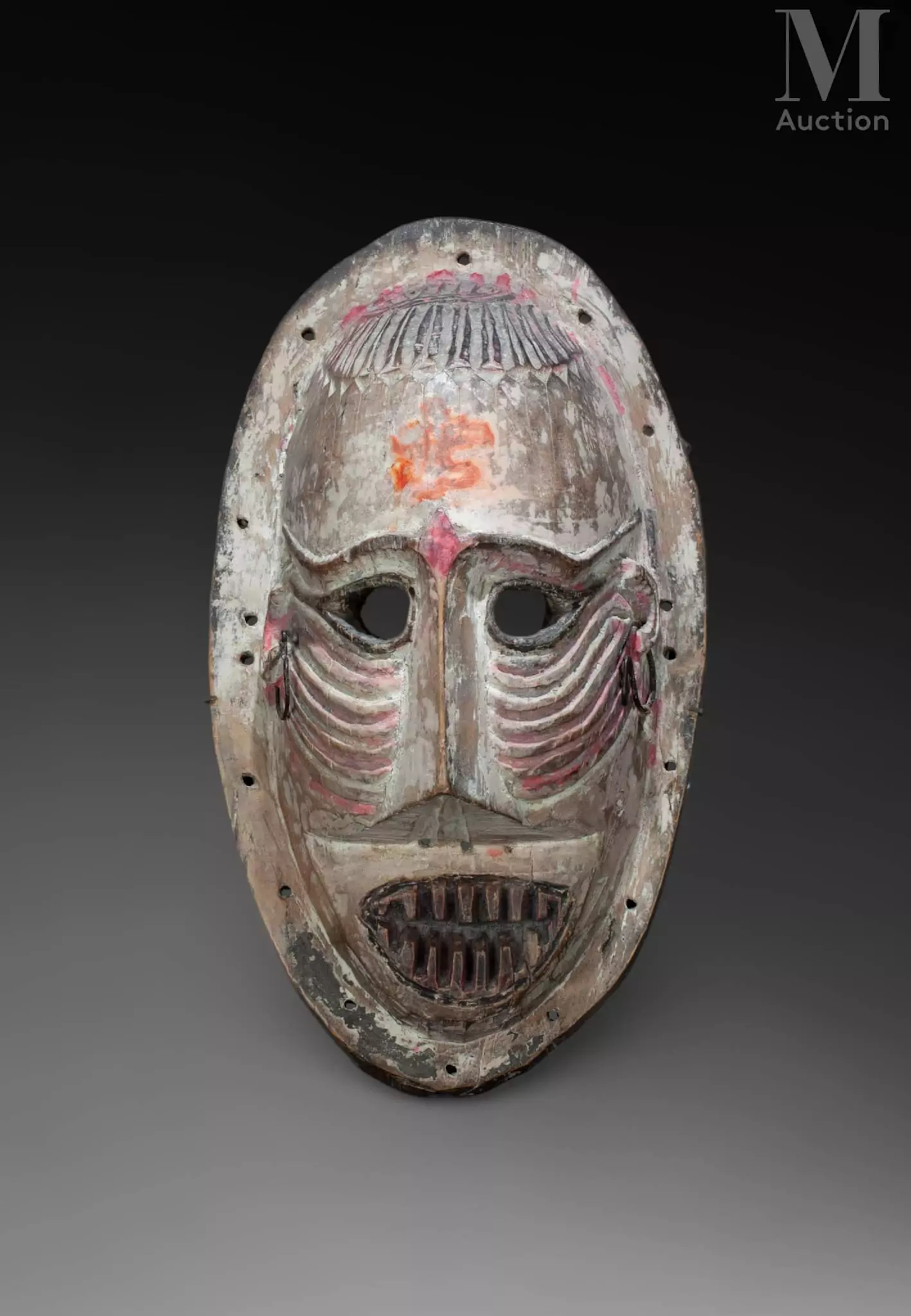 Grand masque, visage et front scarifiés, bouche ouverte montrant les dents.