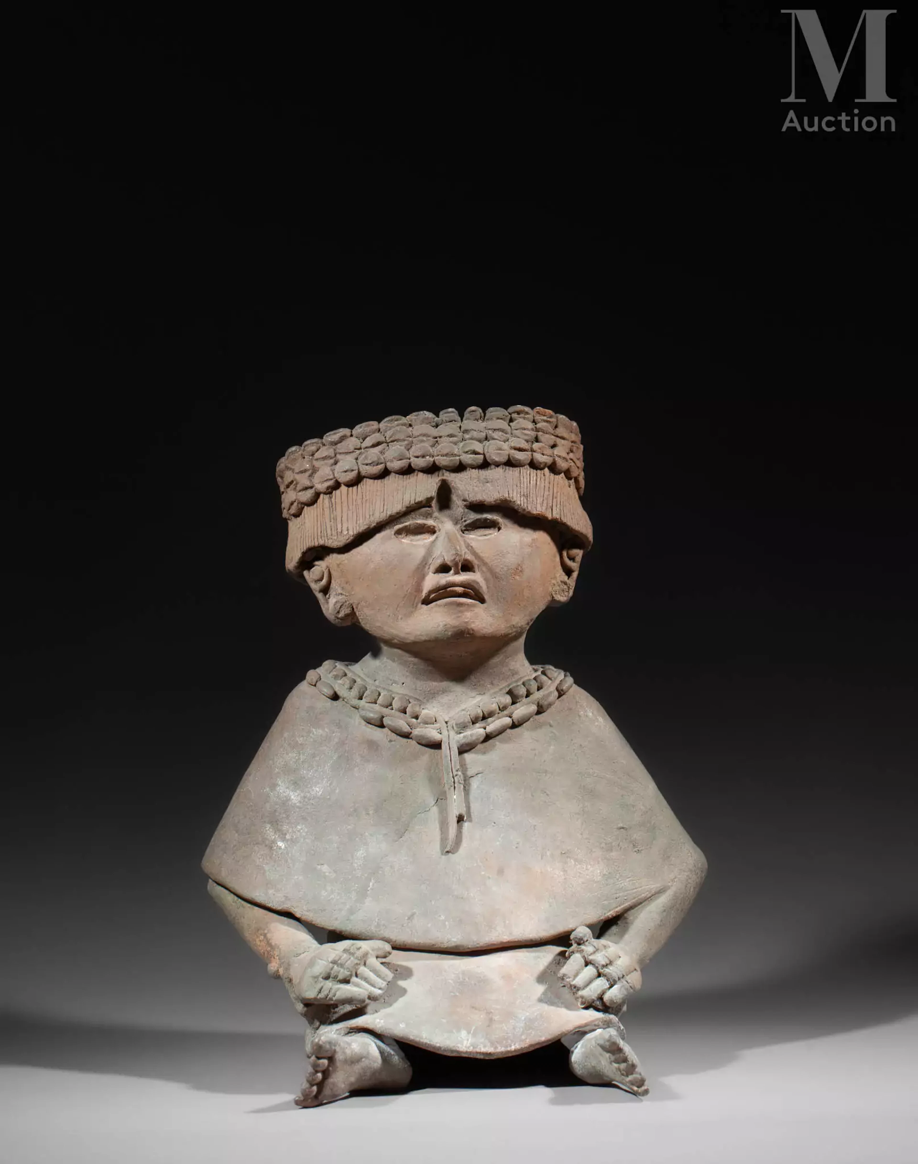 - Prêtresse assise vêtue d’un huipil.