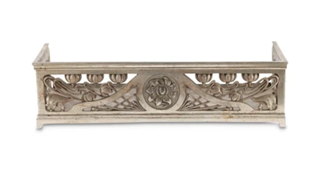 A fire fender with floral decoration, c. 1900