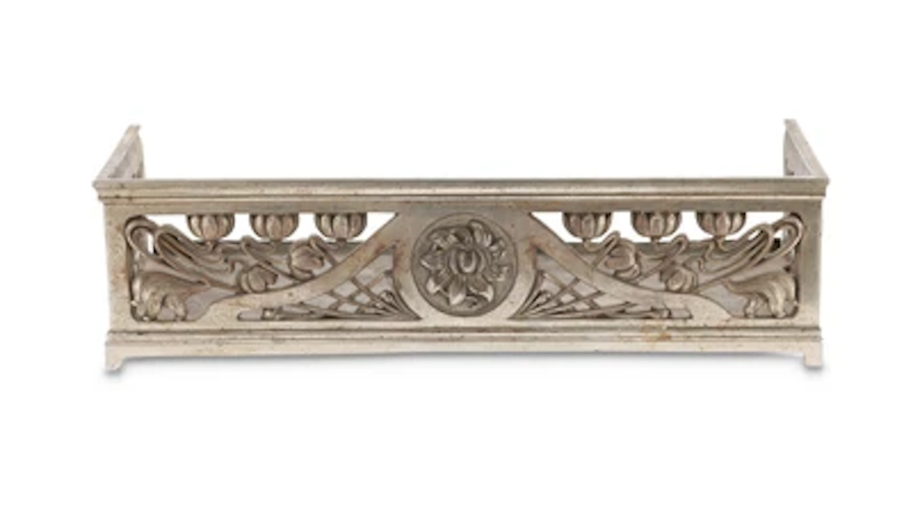A fire fender with floral decoration, c. 1900