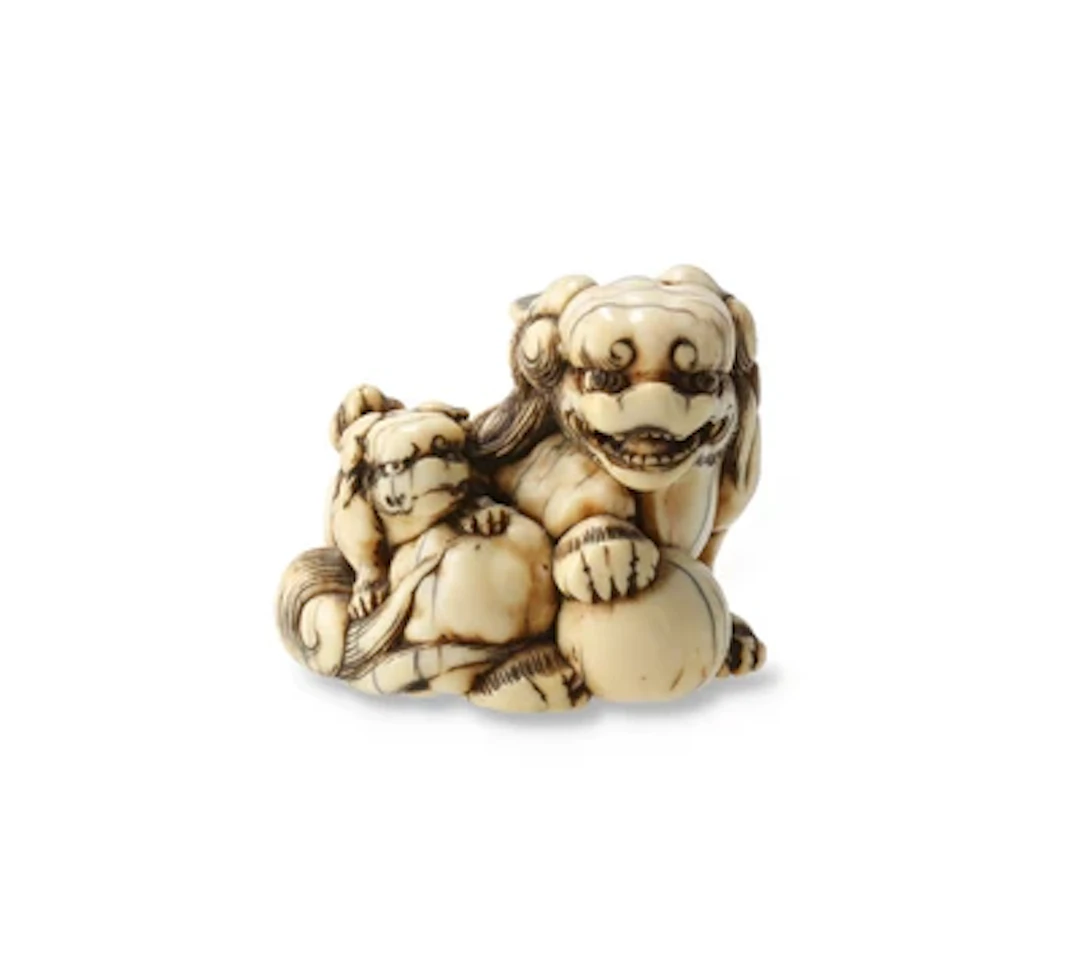 Netsuke eines shishi mit Jungem und Ball, Japan, 19. Jh., signiert