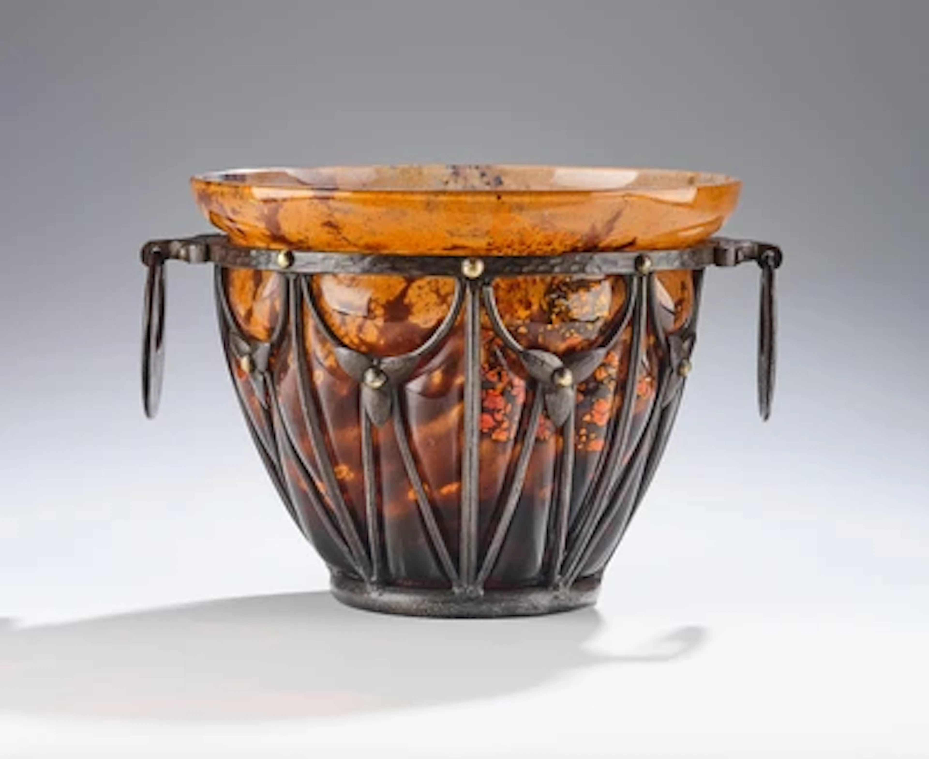 A vase with gold foil inclusions by Daum, Nancy, in a patinated wrought-iron