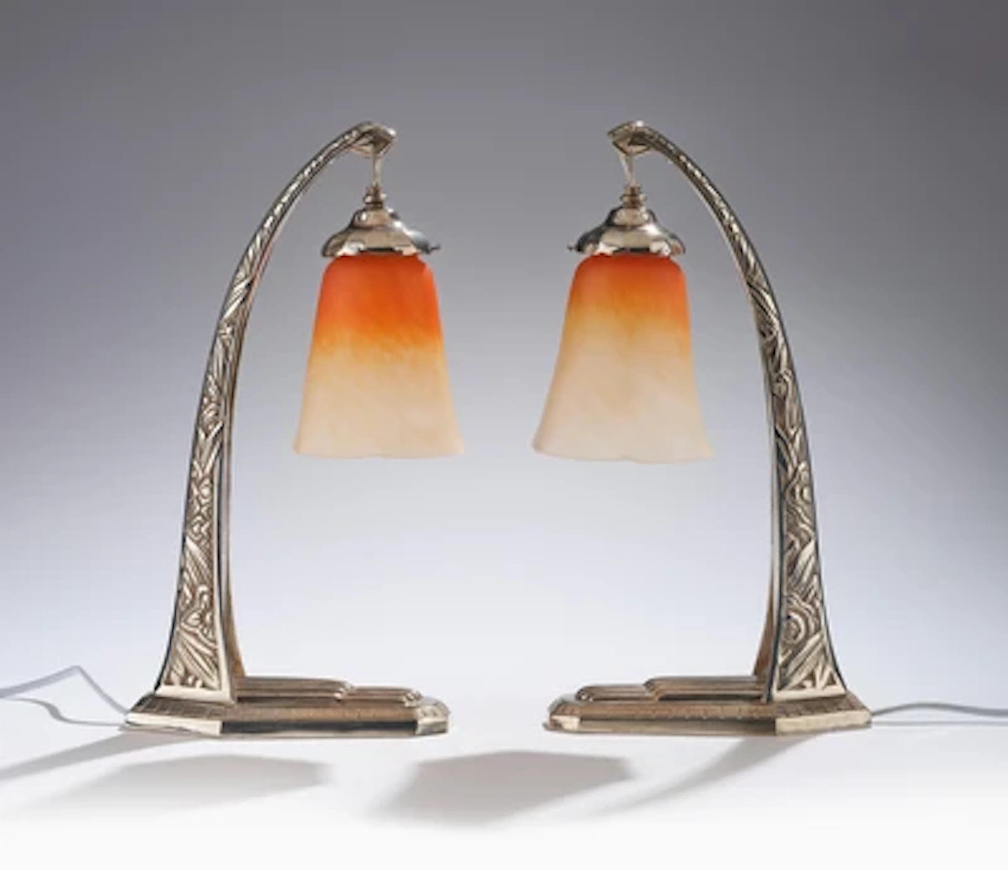 A pair of table lamps with stylised floral motifs and lampshades