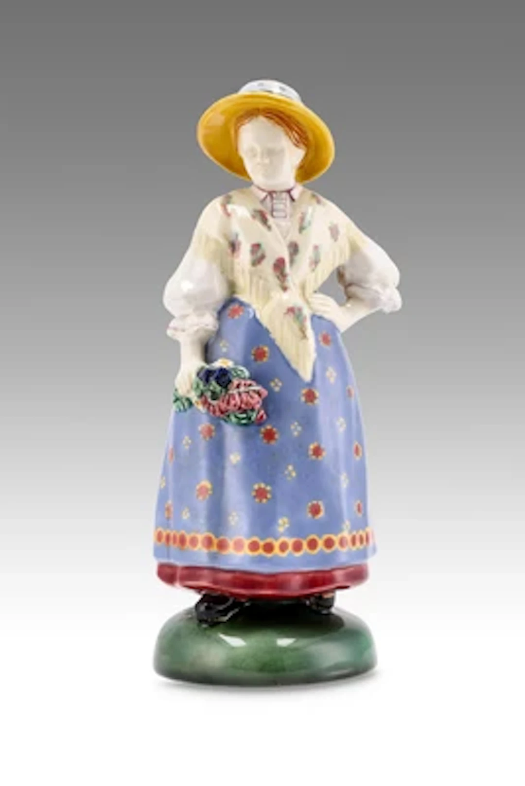 A lady in traditional costume with straw hat and bouquet of flowers