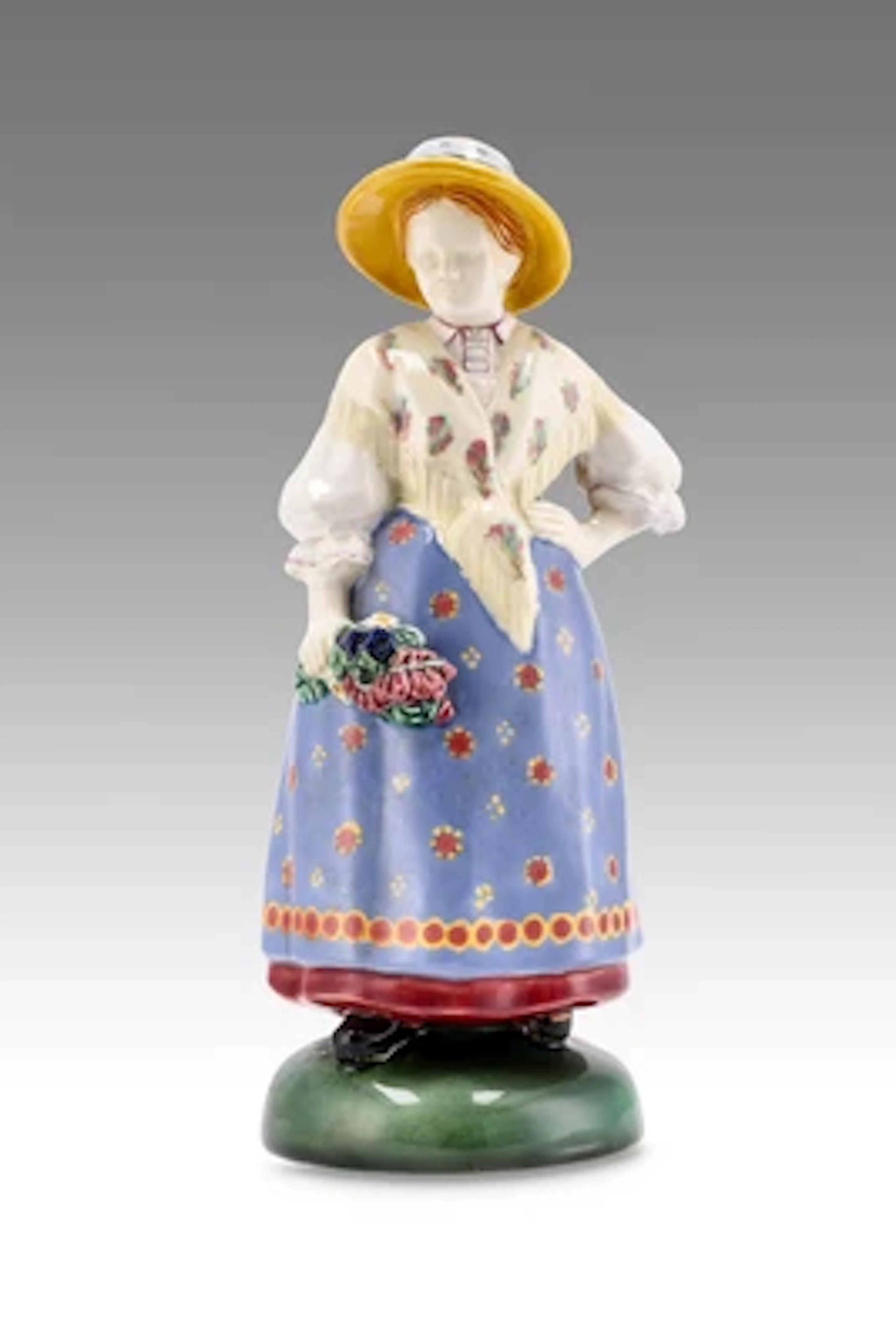 A lady in traditional costume with straw hat and bouquet of flowers