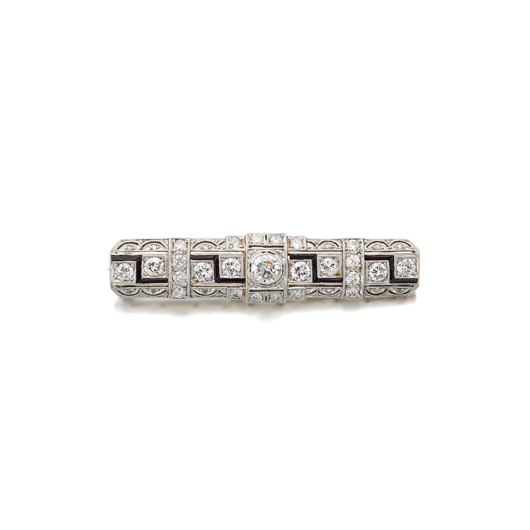 An Art Deco Diamond, Onyx, Platinum and Gold Bar Brooch, circa 1925