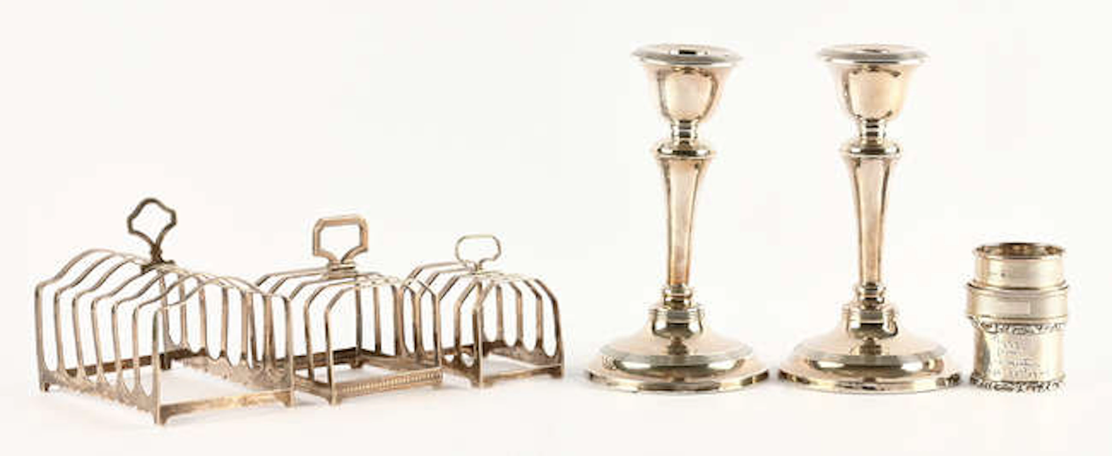 Three toast racks, three napkin rings and a pair of candle sticks, 9.2ozt 289gm