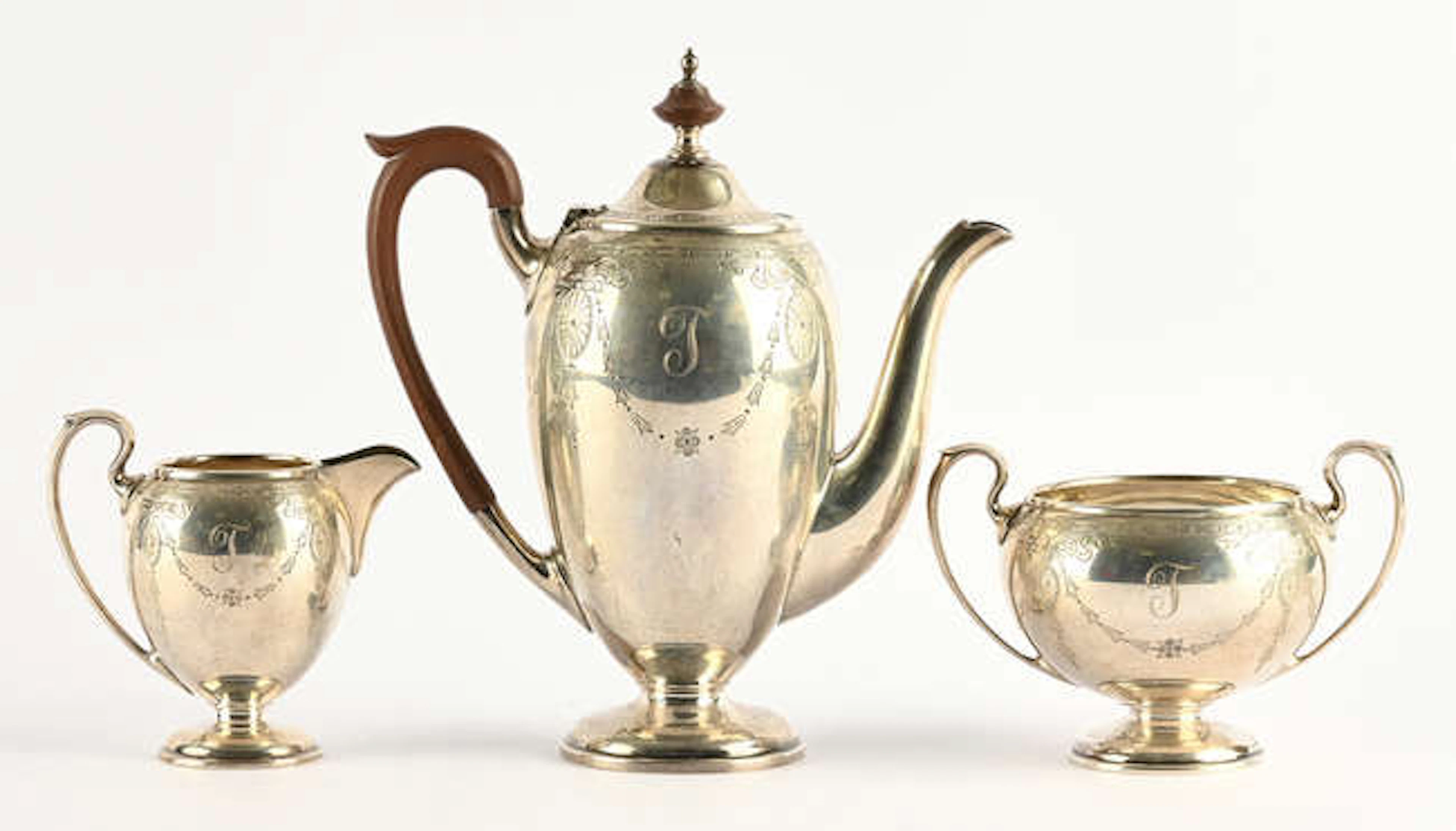 Three piece coffee service engraved with foliate swags, on pedestal