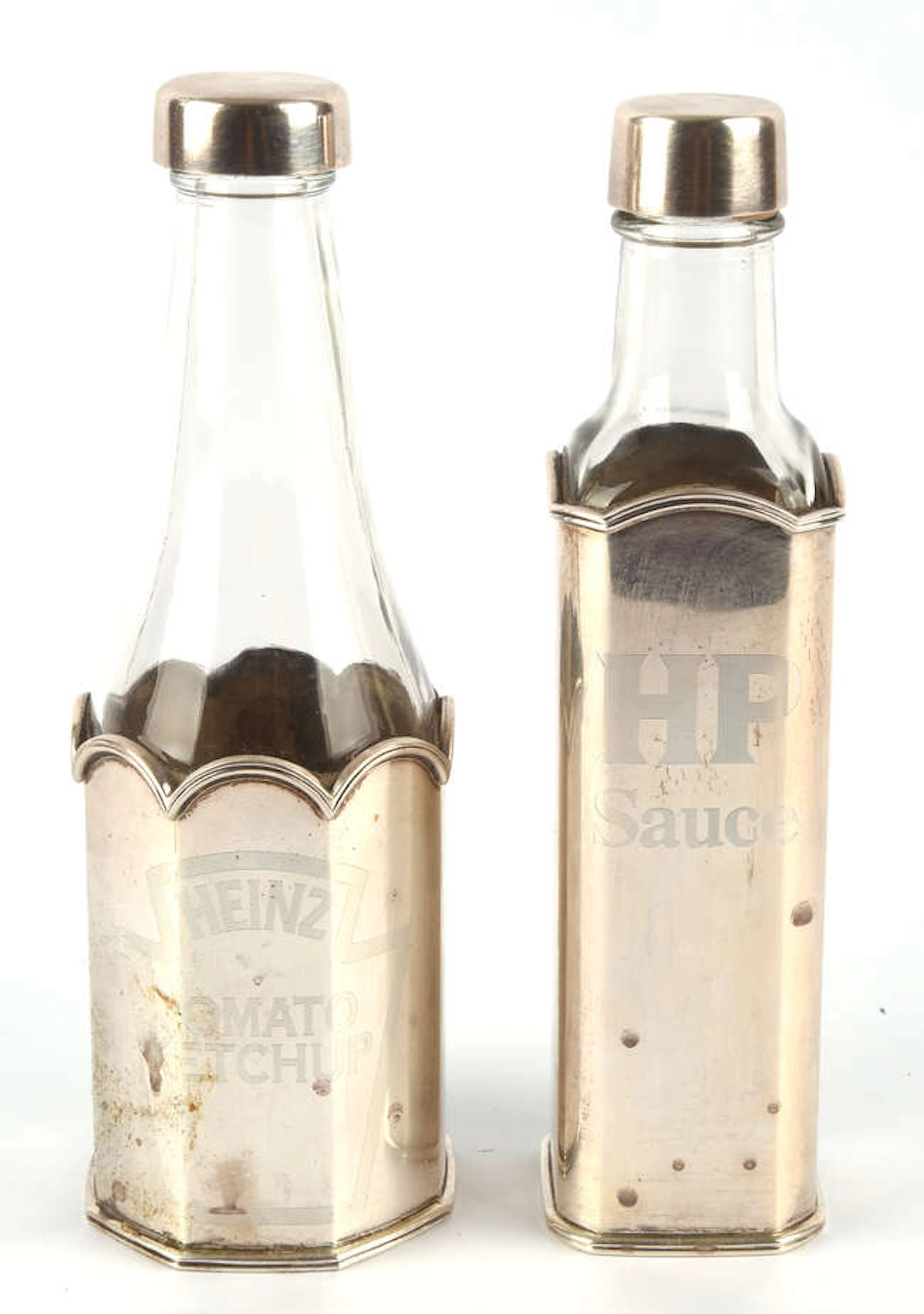 THEO FENNELL, two silver and glass sauce bottles, the silver bodies